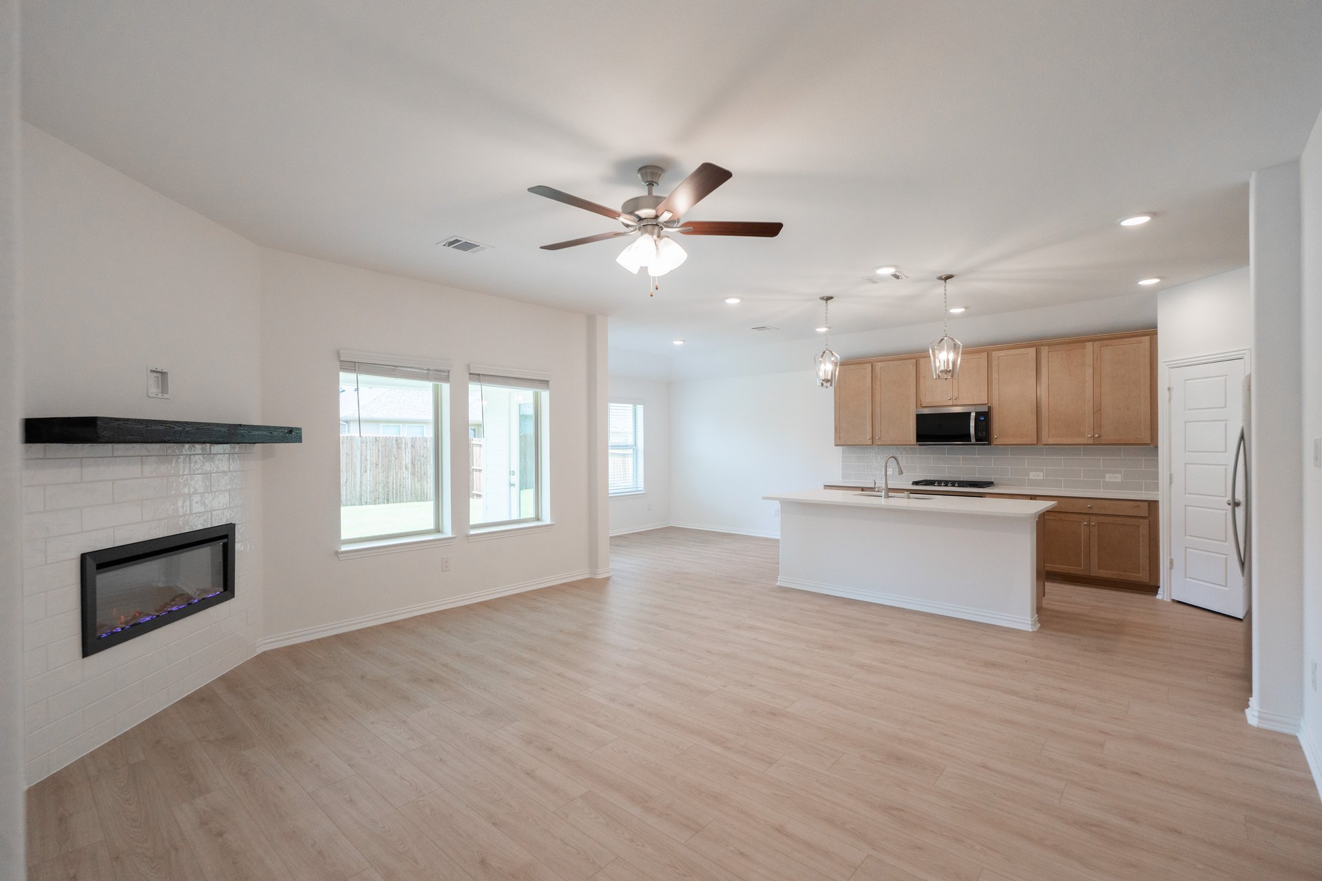 open great room with wood floors and fireplace