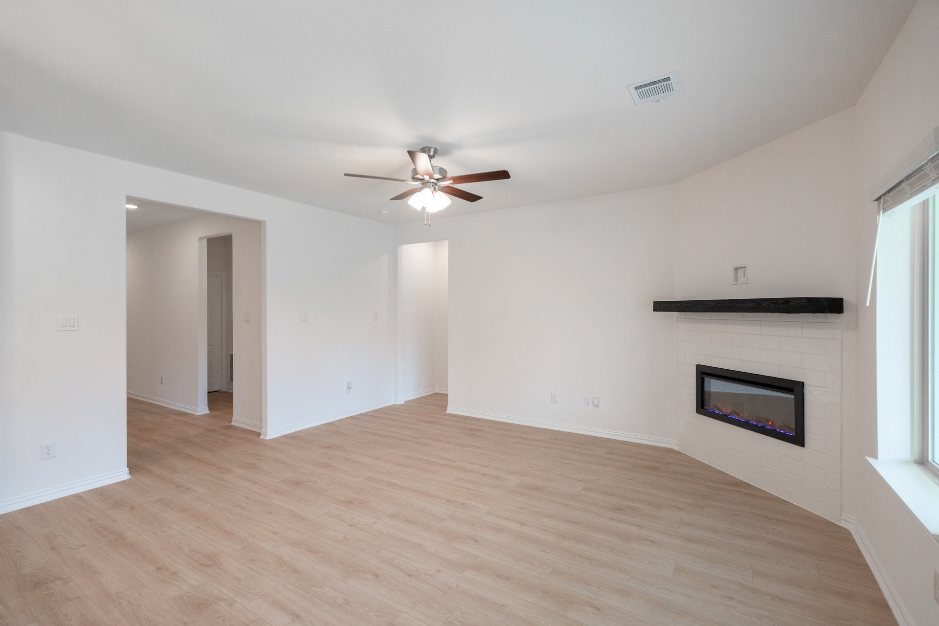 open great room with wood floors and fireplace