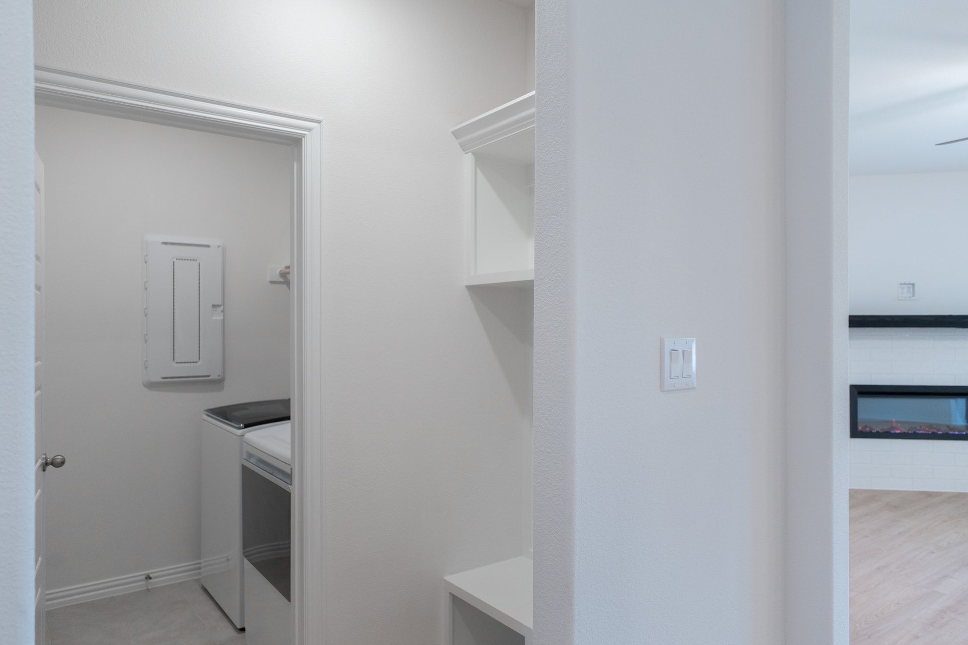 mudroom with wood floors and white shelves with bench