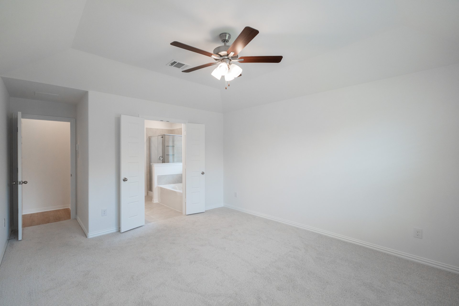 primary bedroom with carpet and ceiling fan