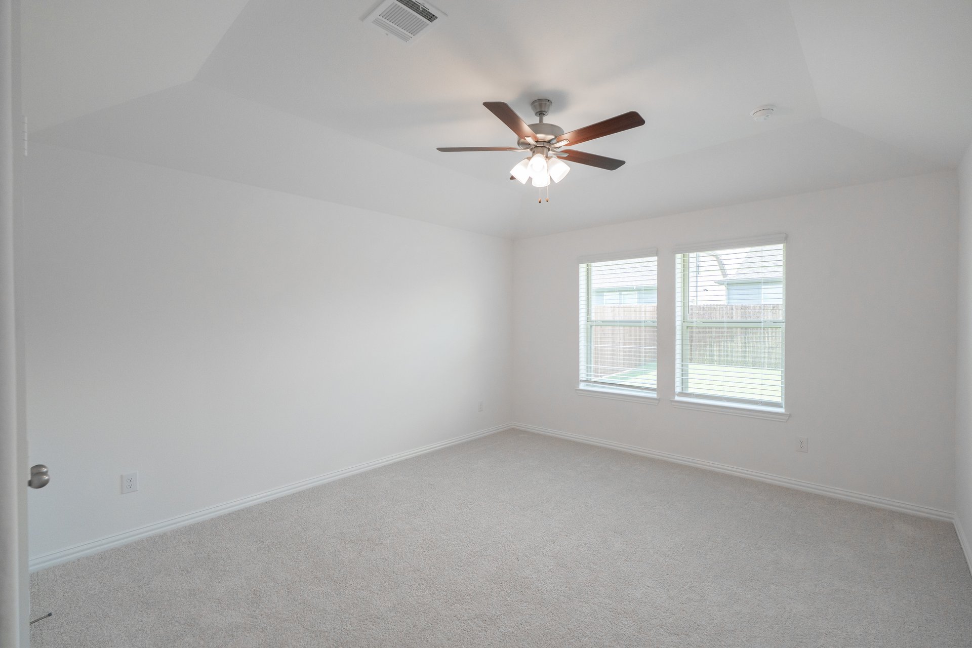 primary bedroom with carpet and windows