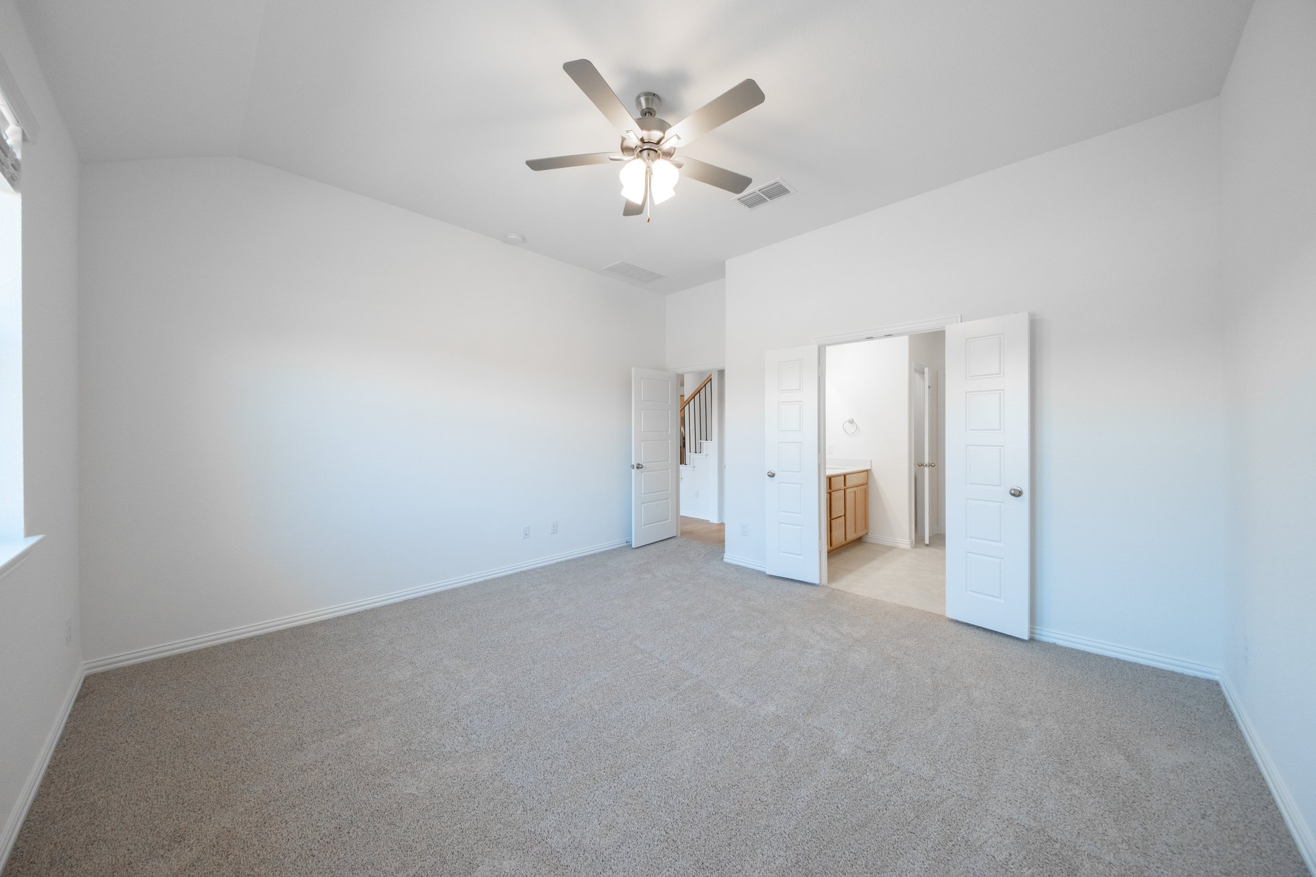 primary bedroom with carpet and ceiling fan