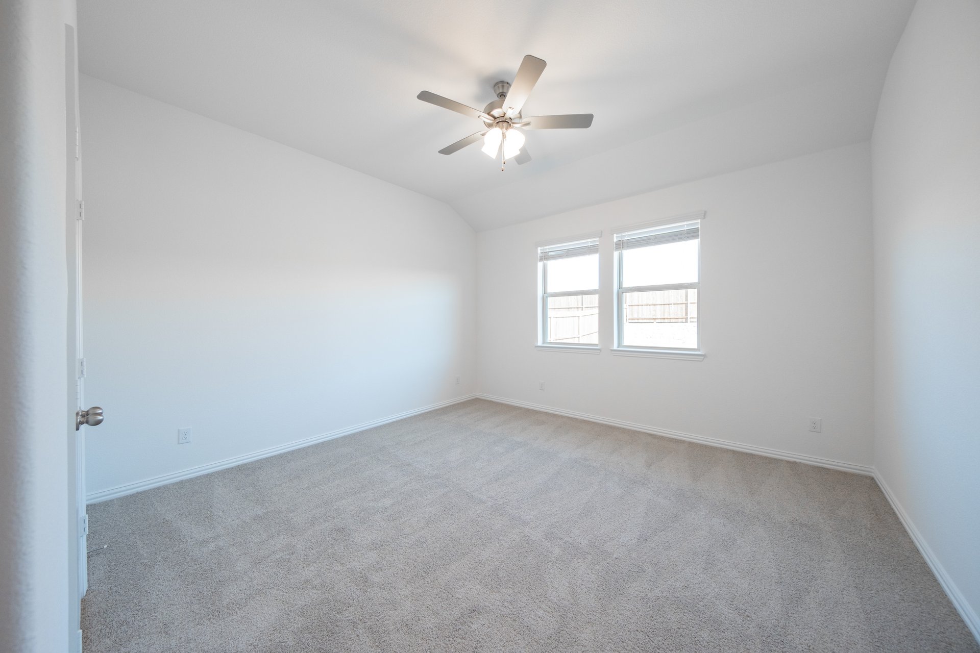 primary bedroom with carpet and windows