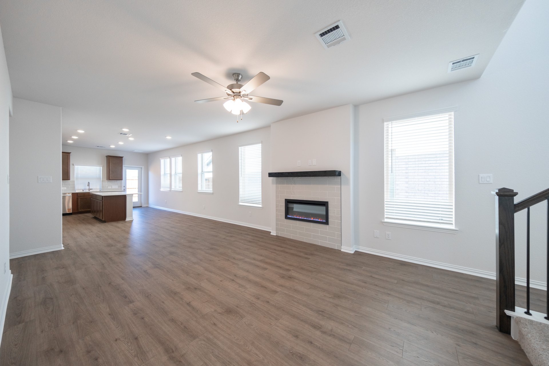 great room with fireplace and ceiling fan