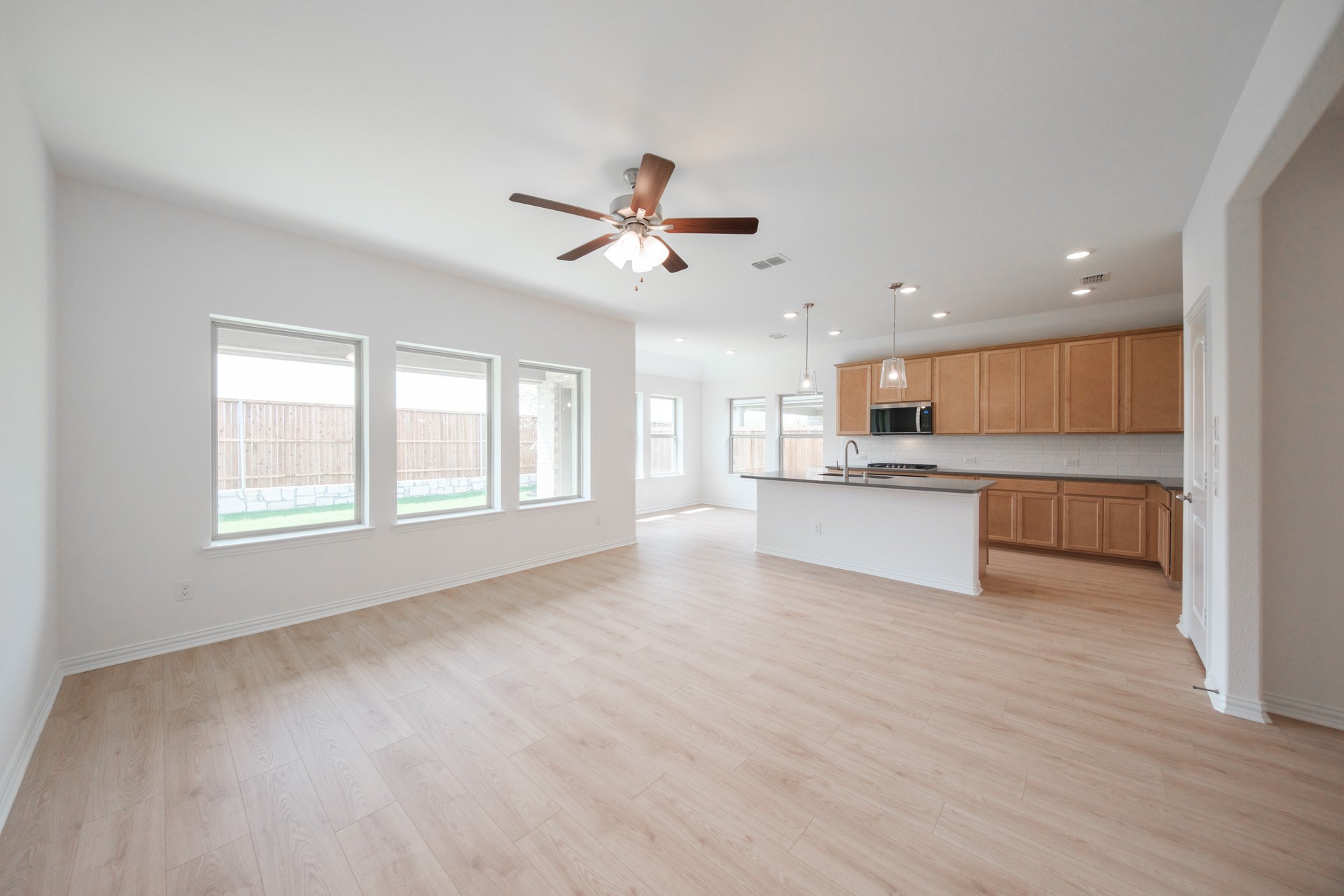 open great room with wood floors and ceiling fan
