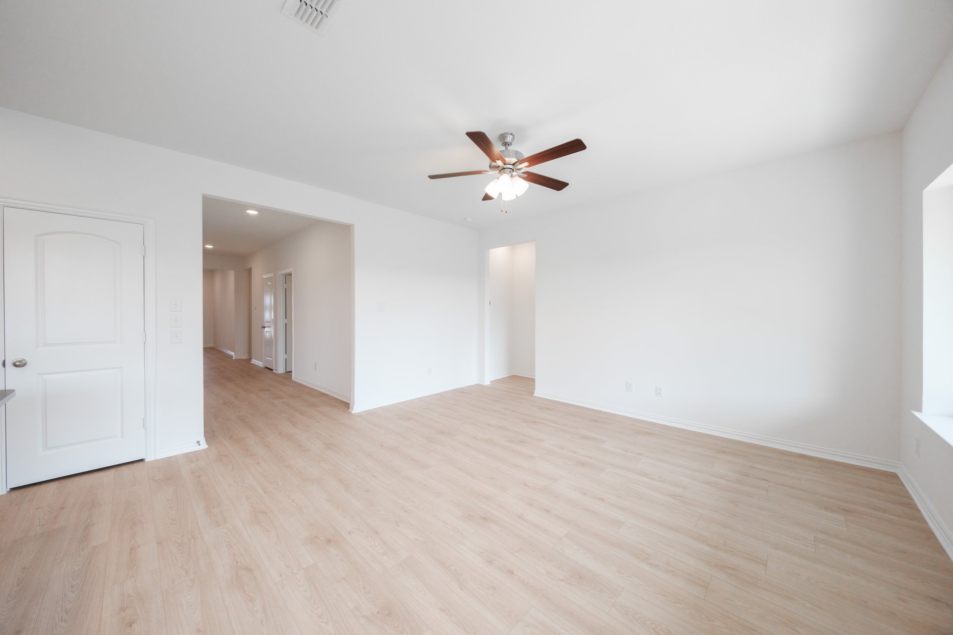 open great room with wood floors and ceiling fan