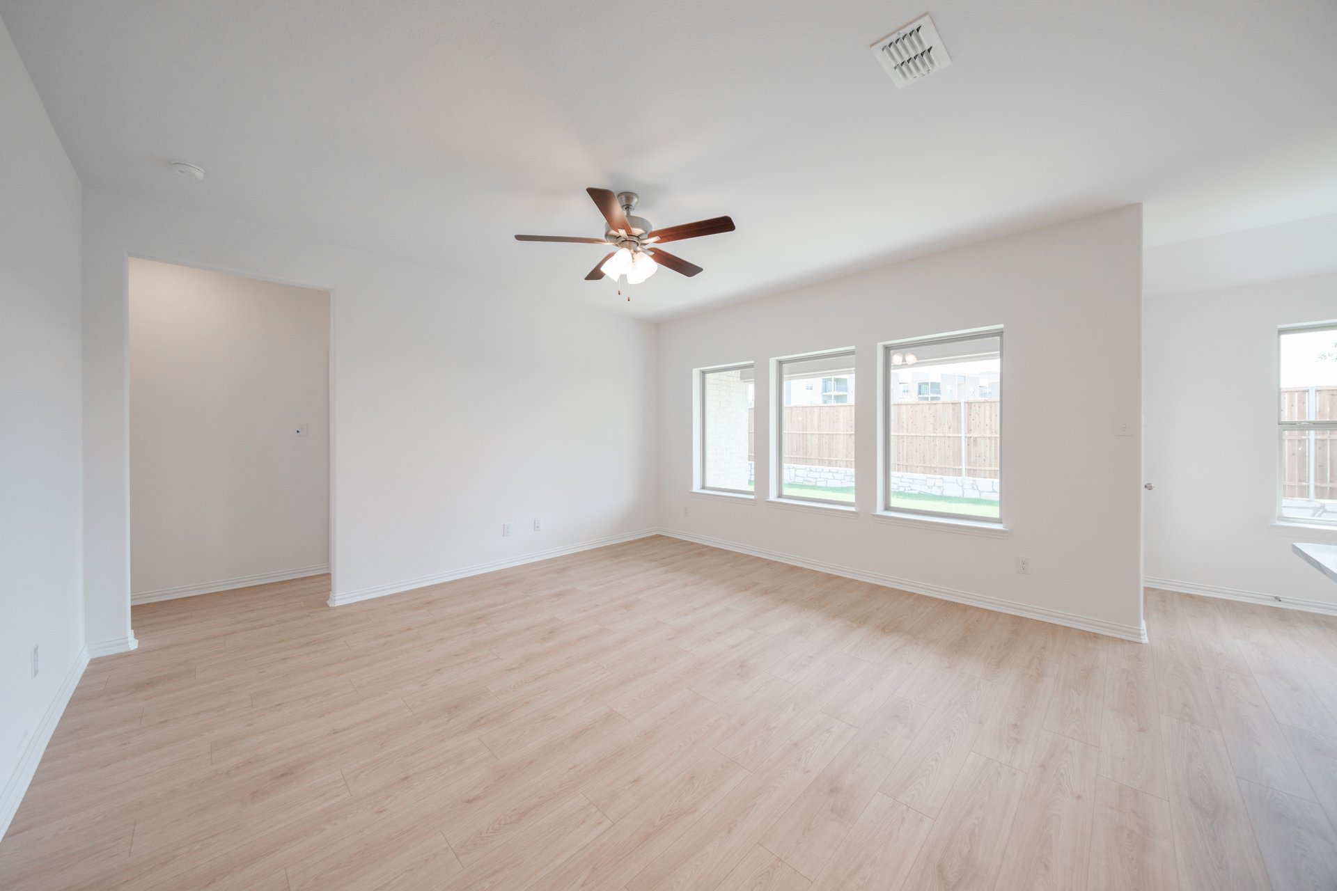 open great room with wood floors and ceiling fan