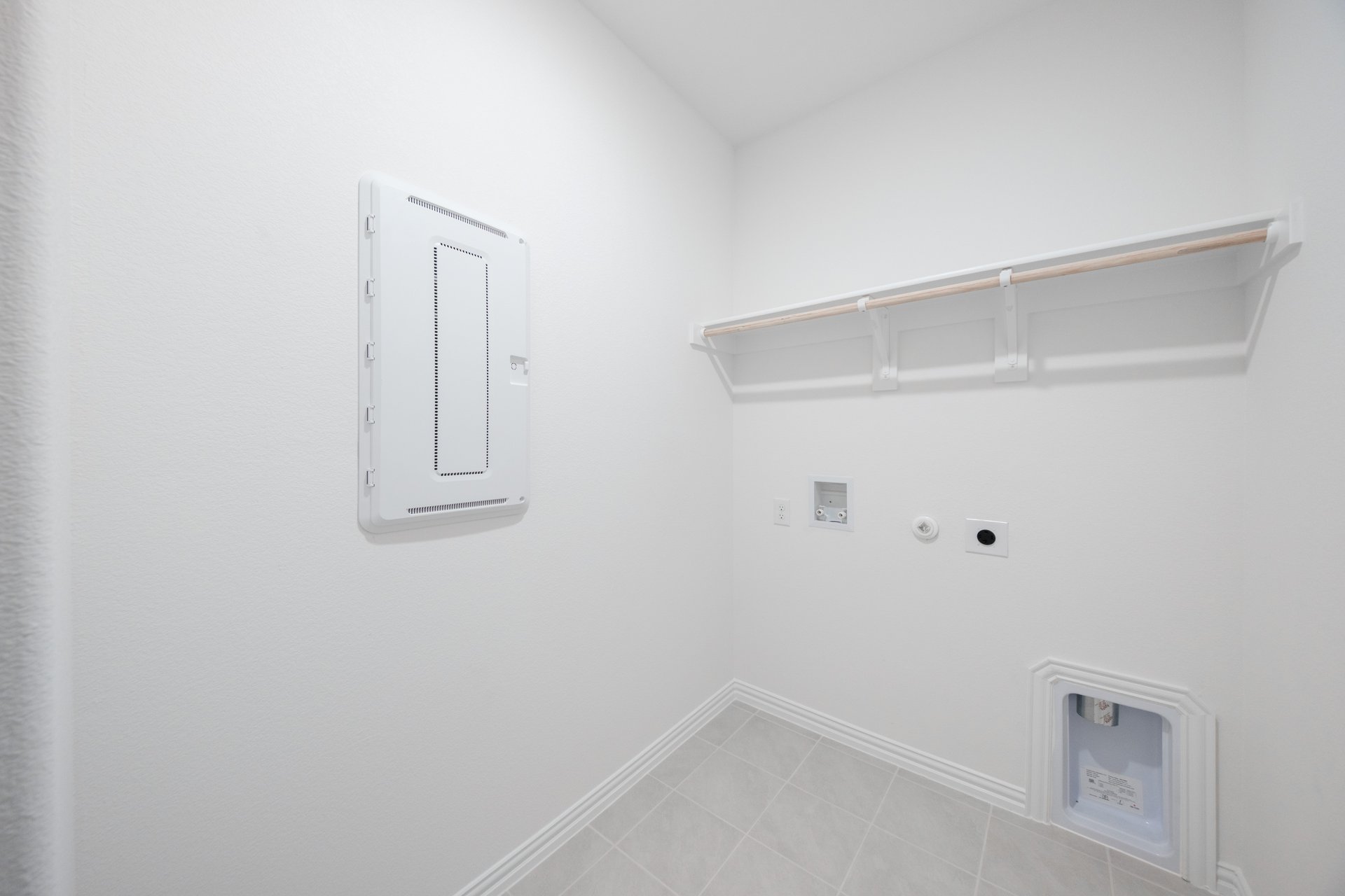 laundry room with tile floors and white shelf