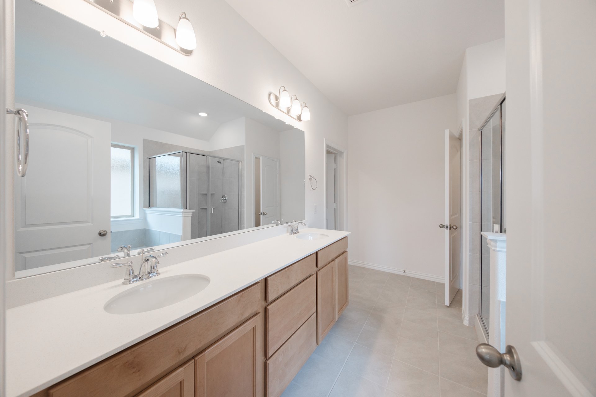 primary bathroom with two sinks and tile floors