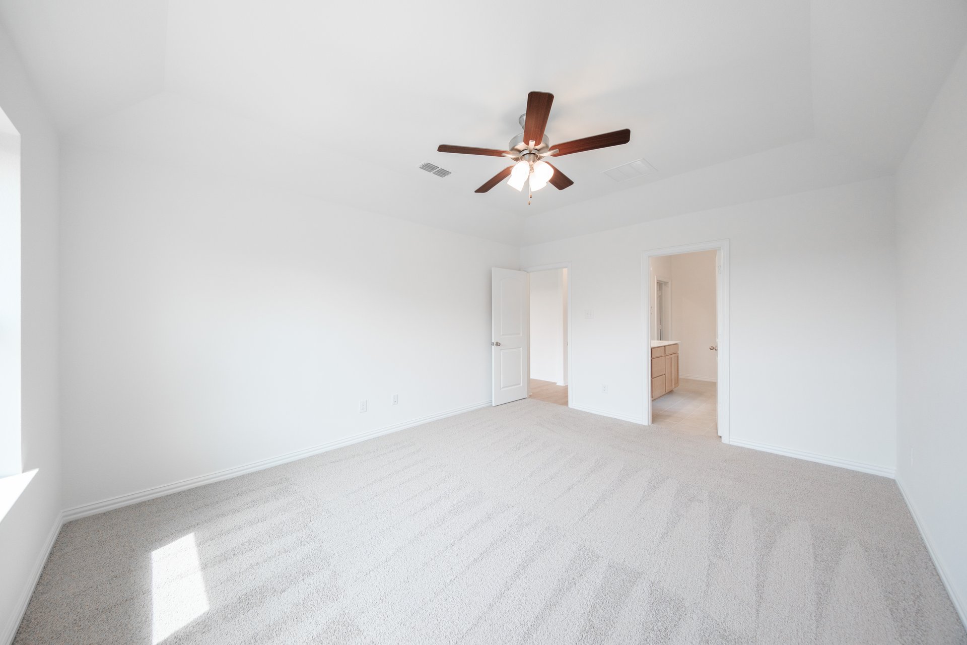 primary bedroom with carpet and ceiling fan