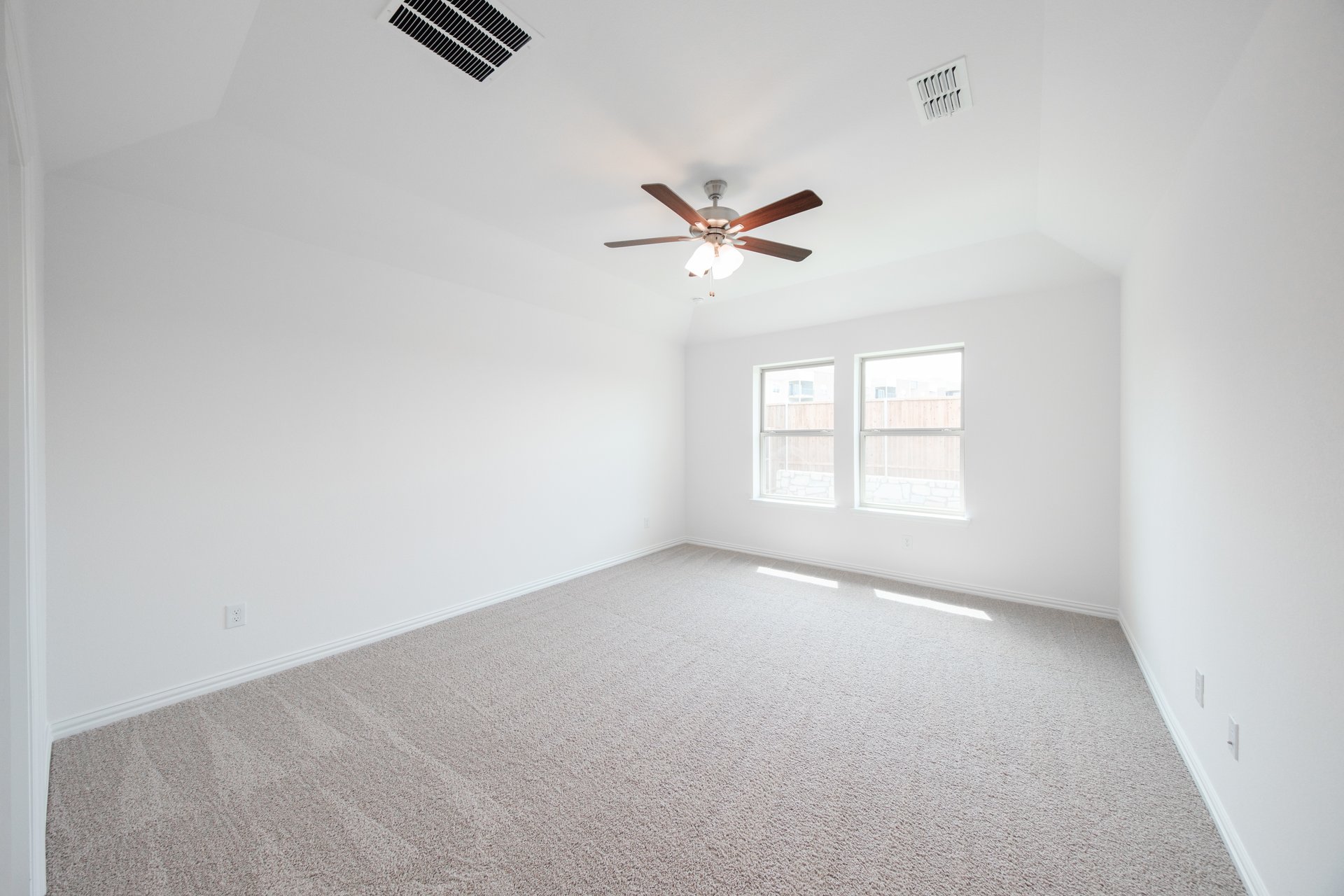 primary bedroom with carpet and windows
