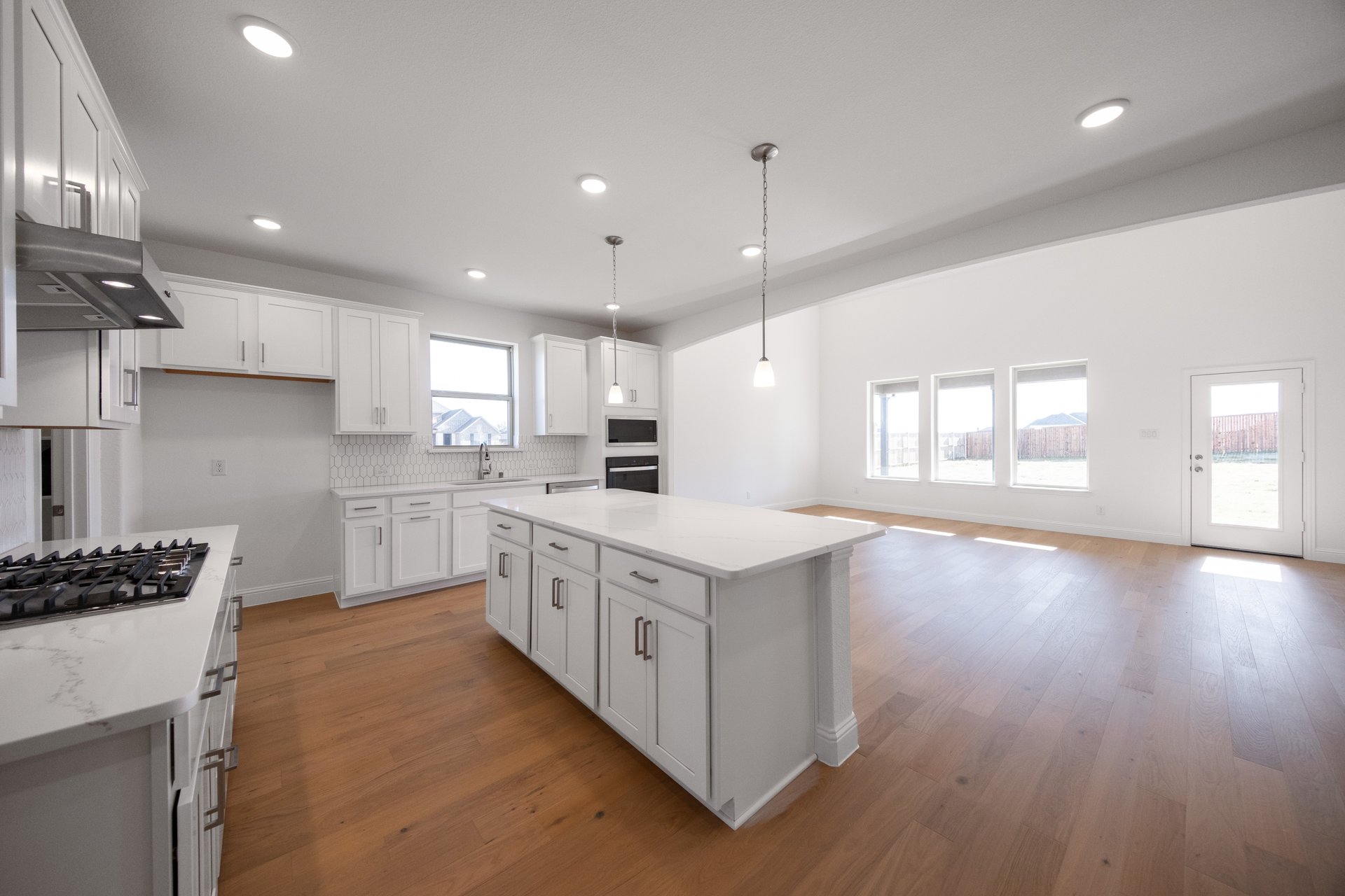 open kitchen with wood floors and white cabinets
