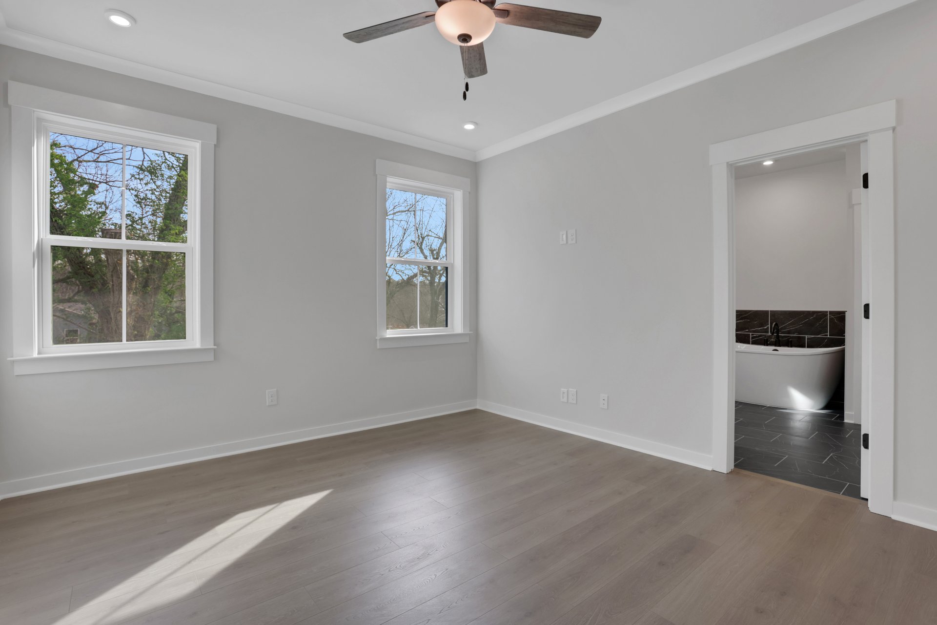 primary bedroom with ensuite bath and hard surface flooring