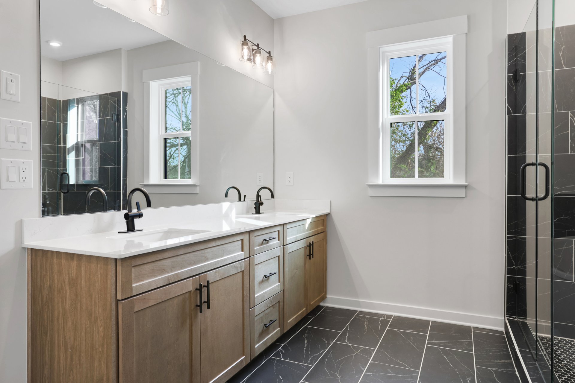 primary bathroom with wood-finish cabinets and tile floors