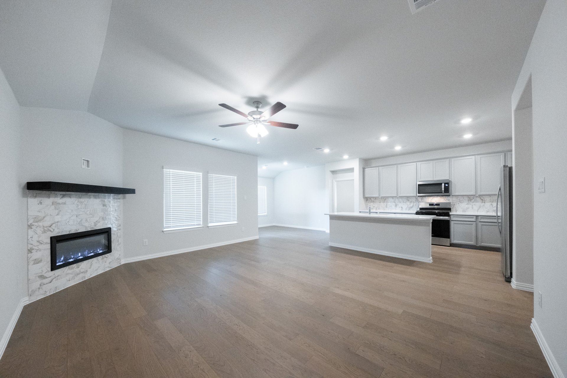 open great room with wood floors and ceiling fan