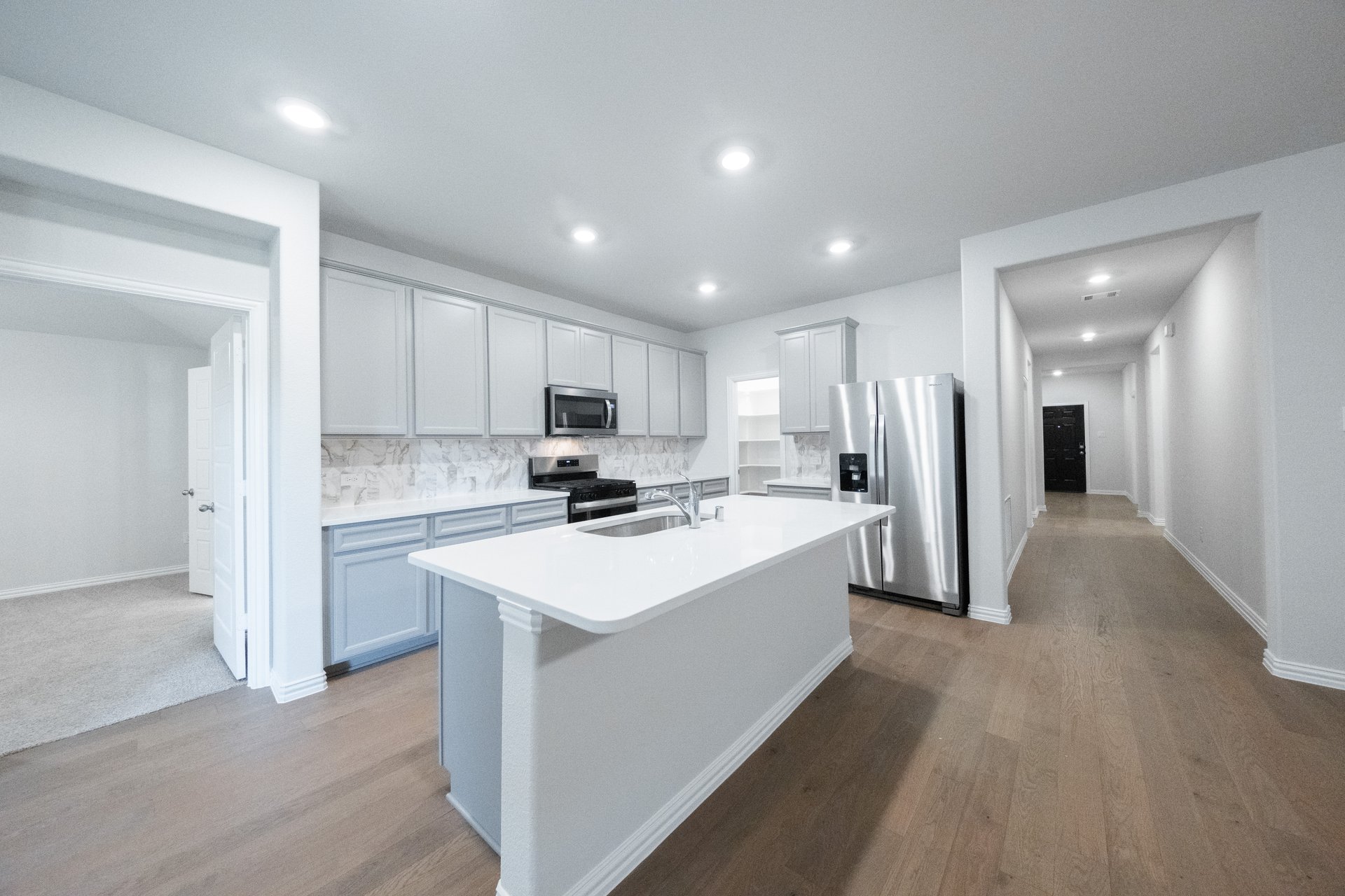 open kitchen with wood floors and gray cabinets