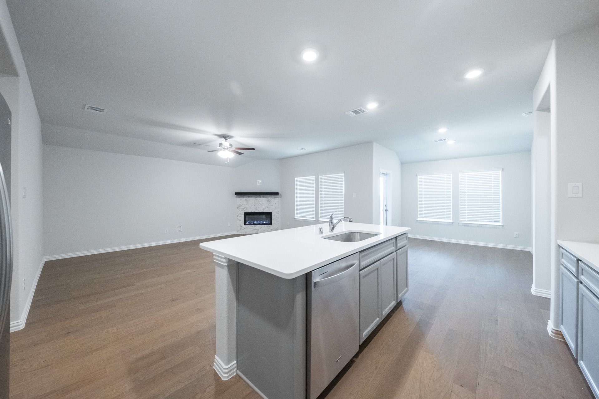 open kitchen with wood floors and gray cabinets
