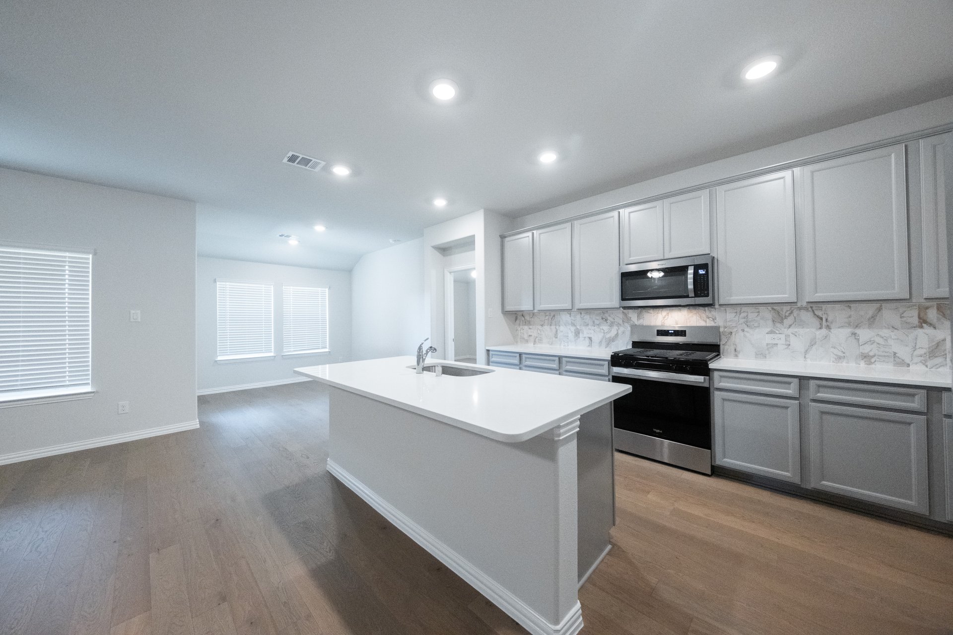 open kitchen with wood floors and gray cabinets