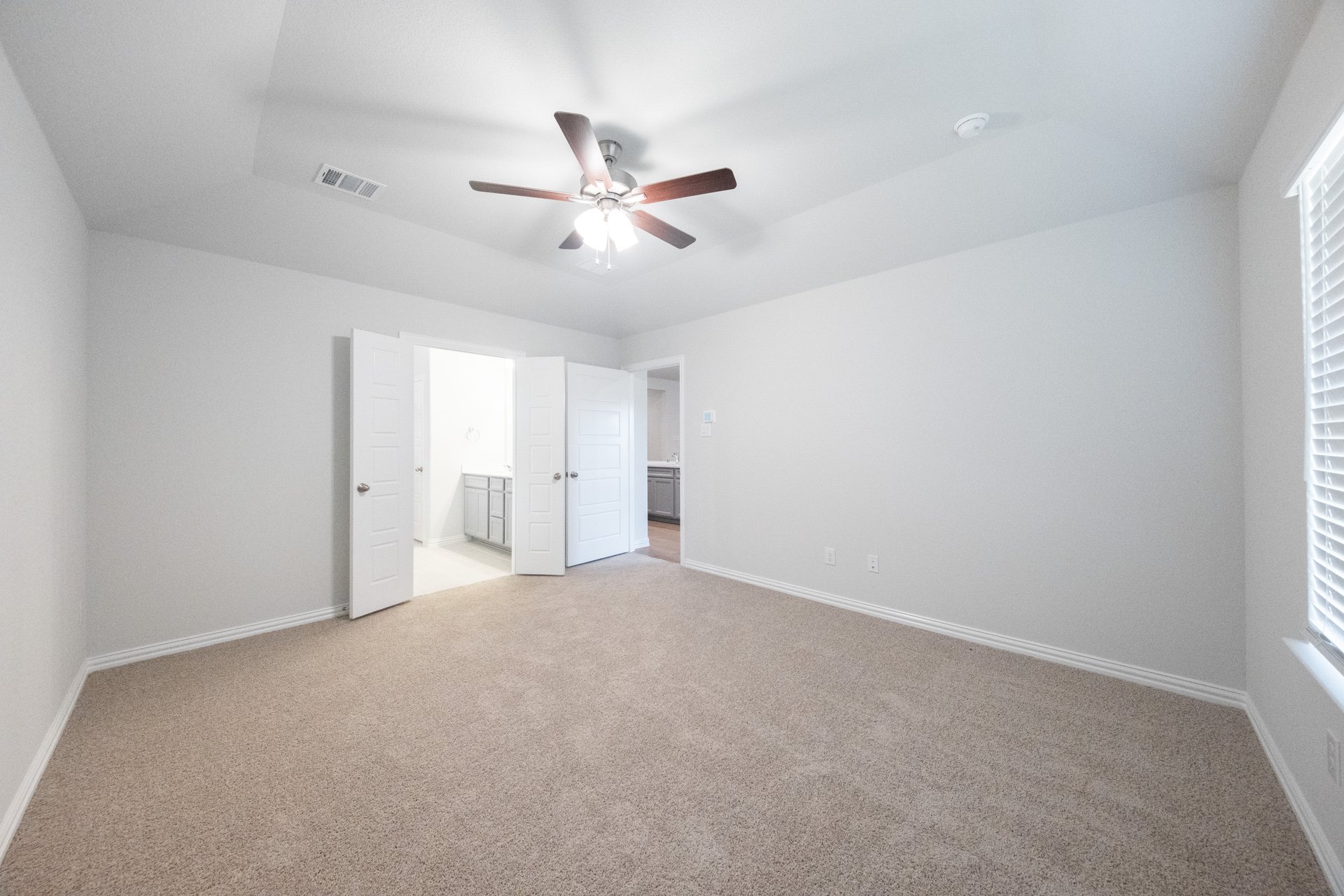 primary bedroom with carpet and ceiling fan