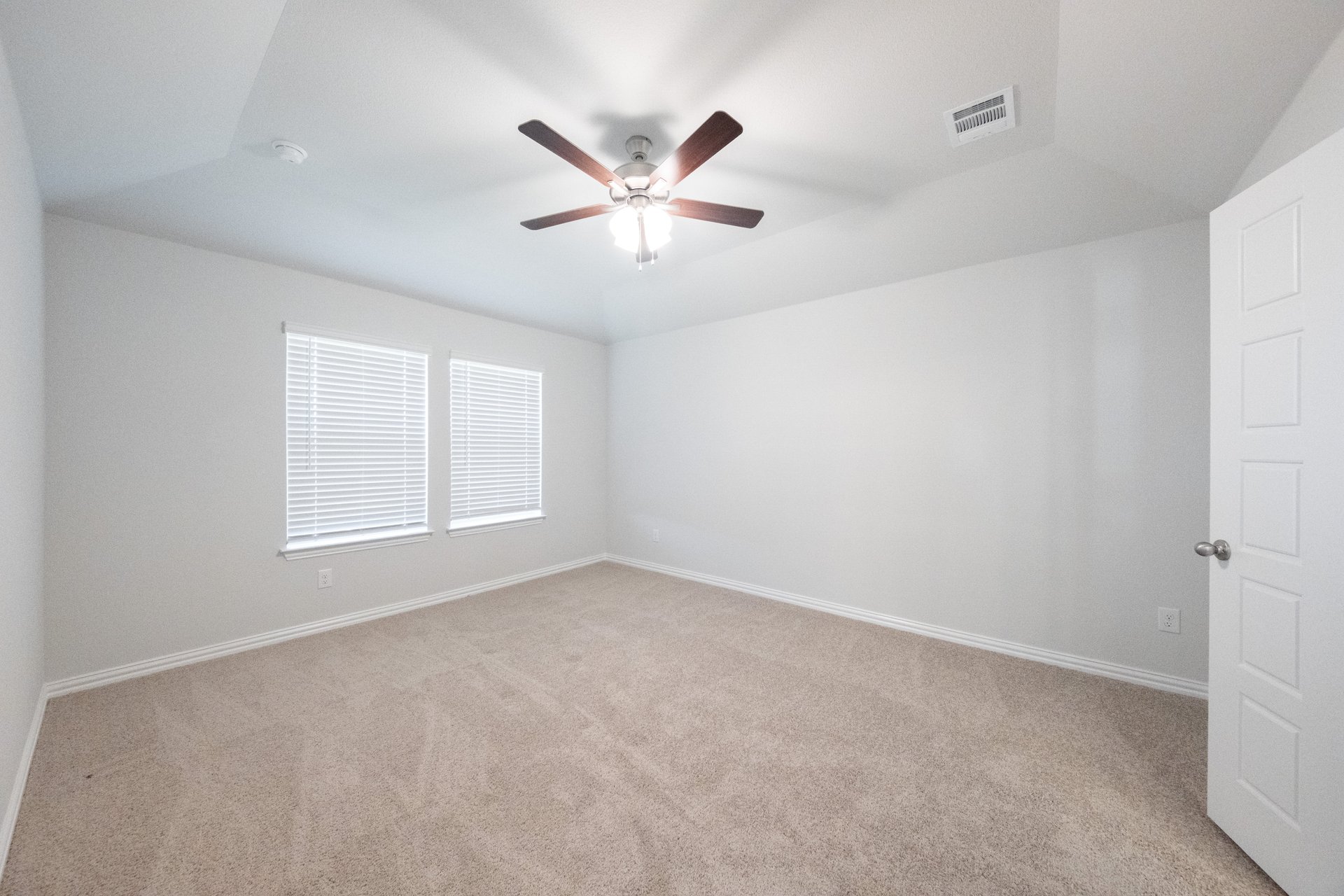 primary bedroom with carpet and windows