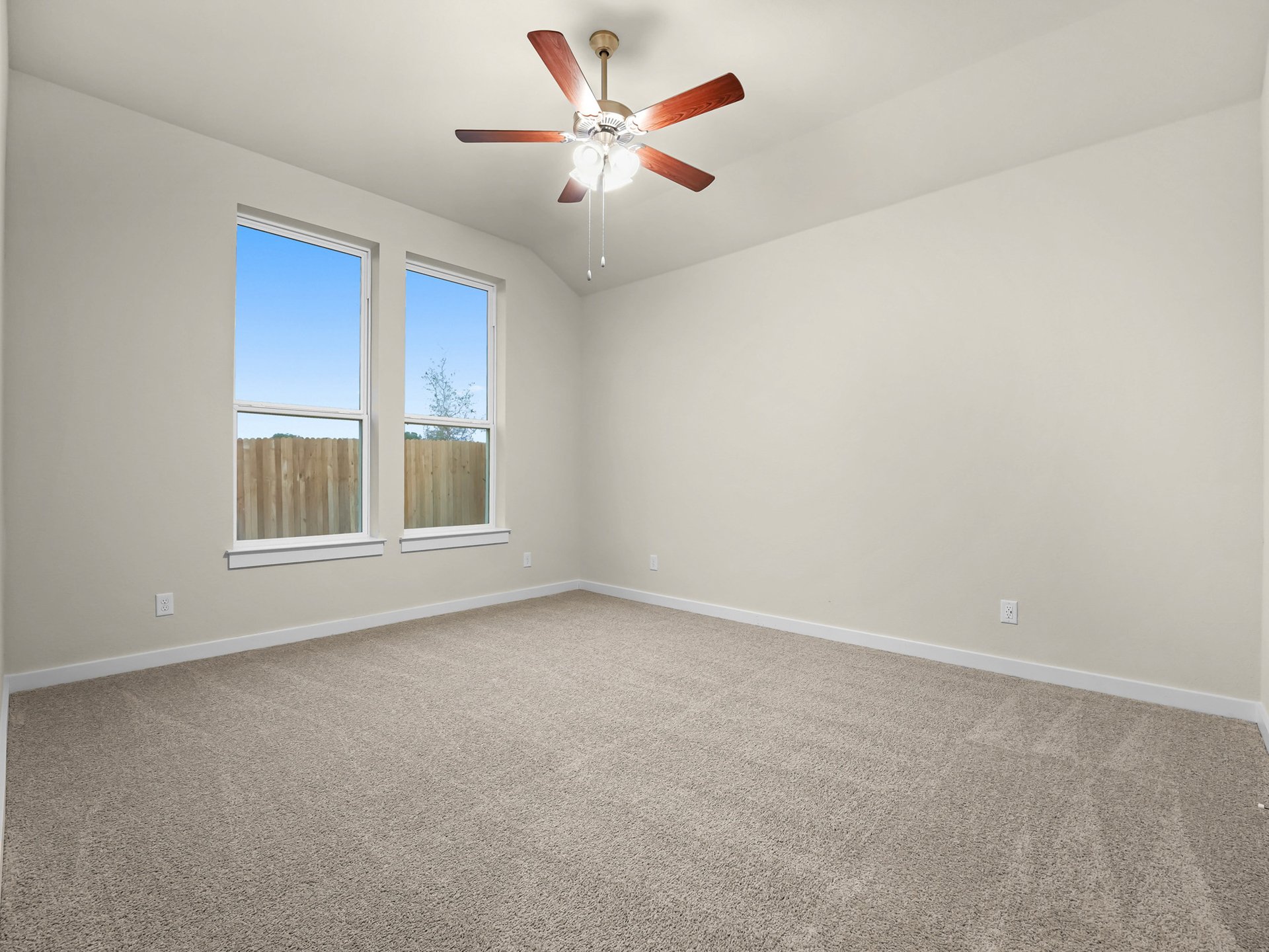 primary bedroom with carpet, ceiling fan and two windows 