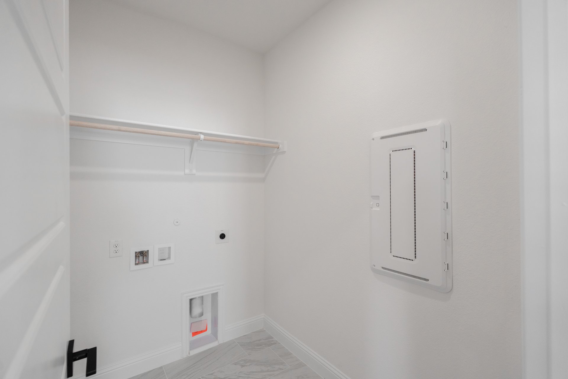 laundry room with tile floors and white shelf