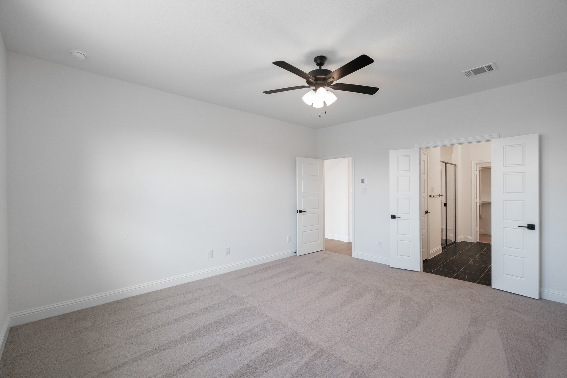 primary bedroom with carpet and ceiling fan