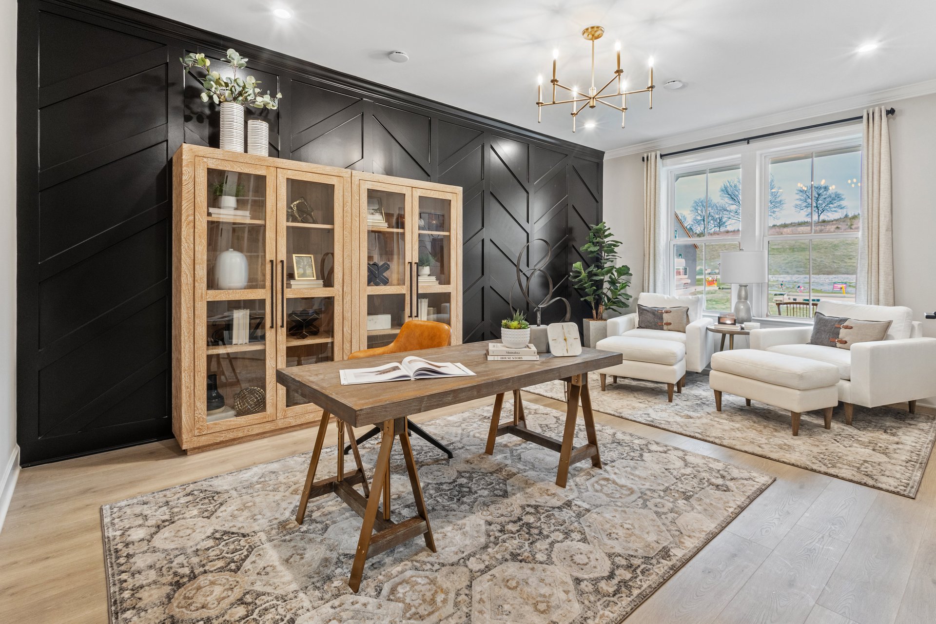 study room with a desk and large book case plus two white ottoman chairs in the corner