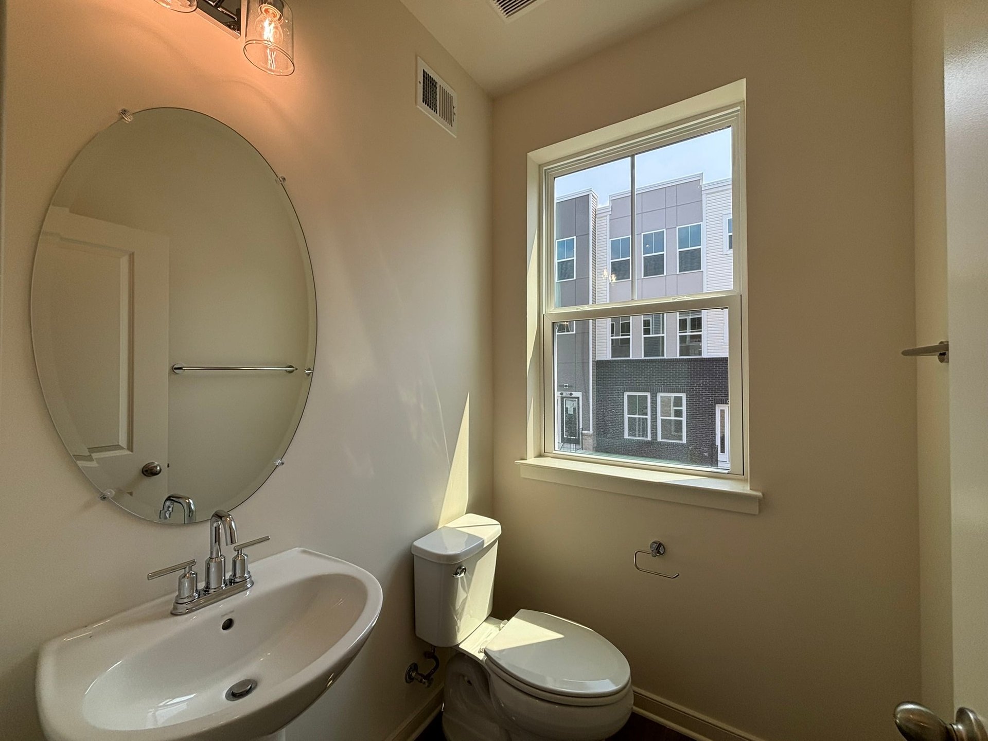 powder room with an oval mirror