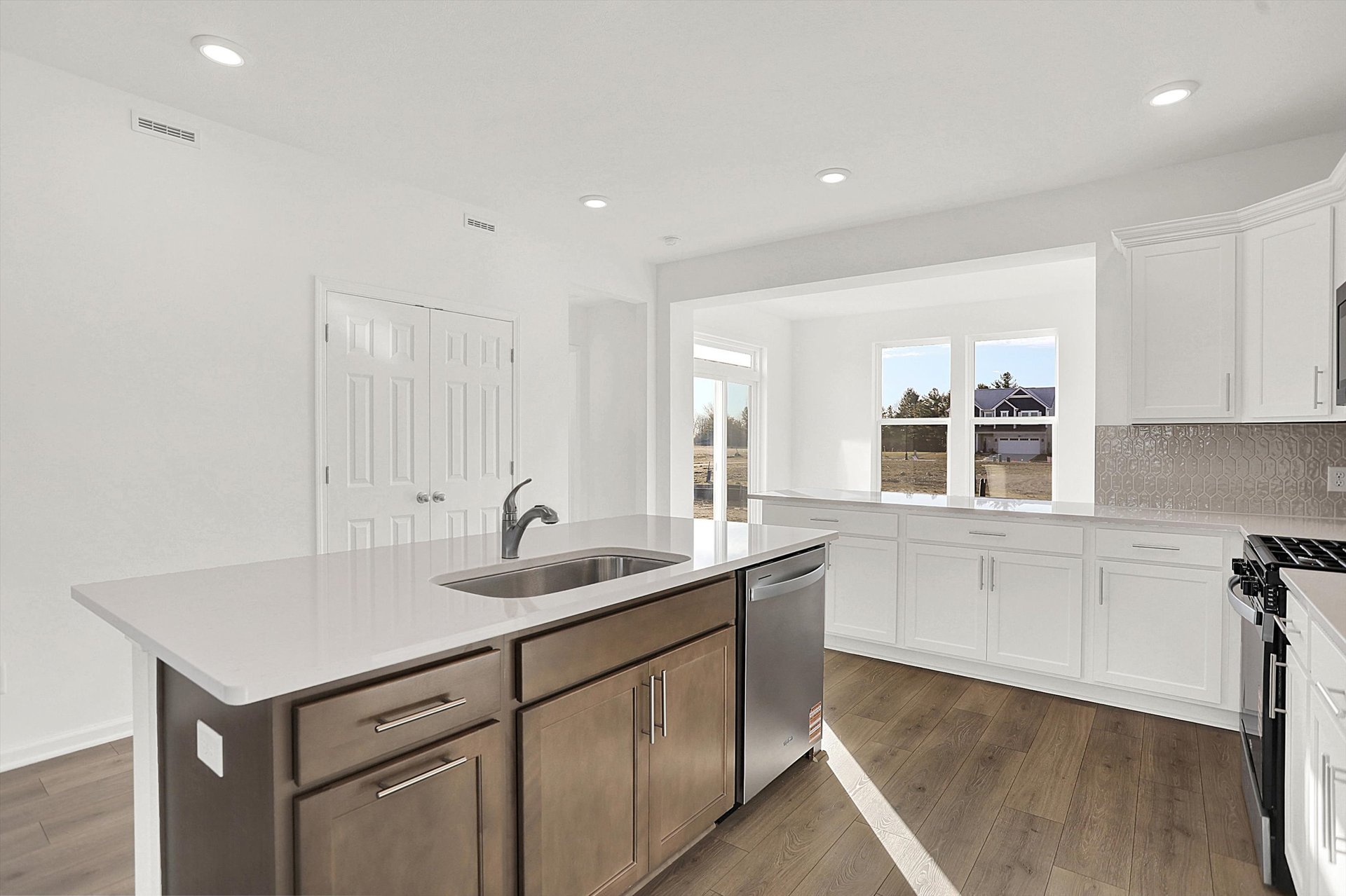 kitchen with white cabinets and island with dark wood cabinets and built-in sink