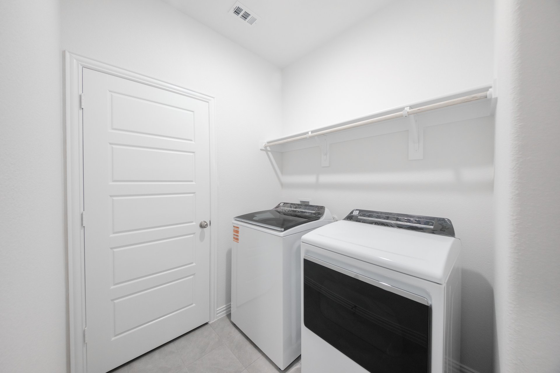 laundry room with tile and white shelves