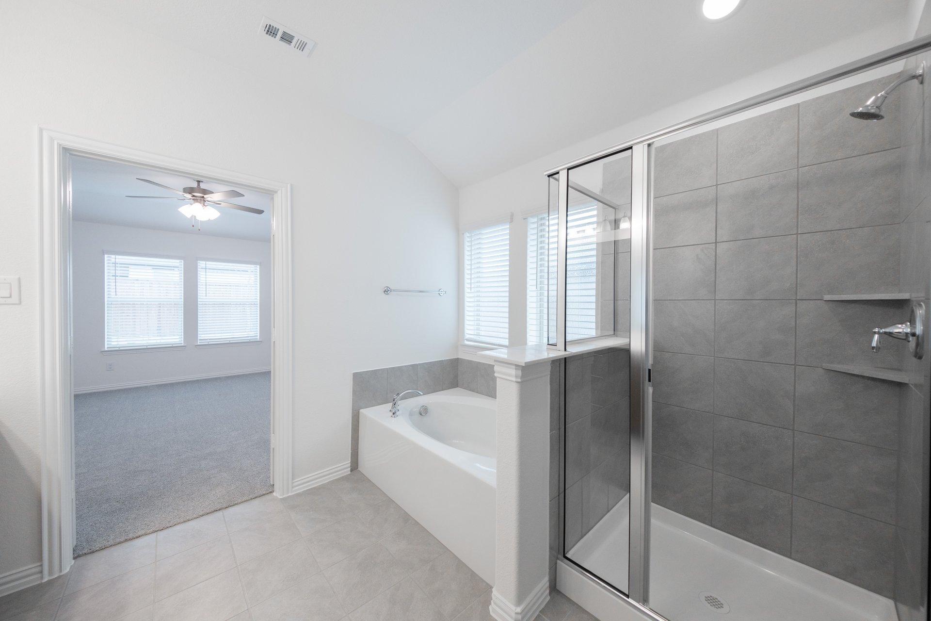 primary bathroom with shower and brown cabinets