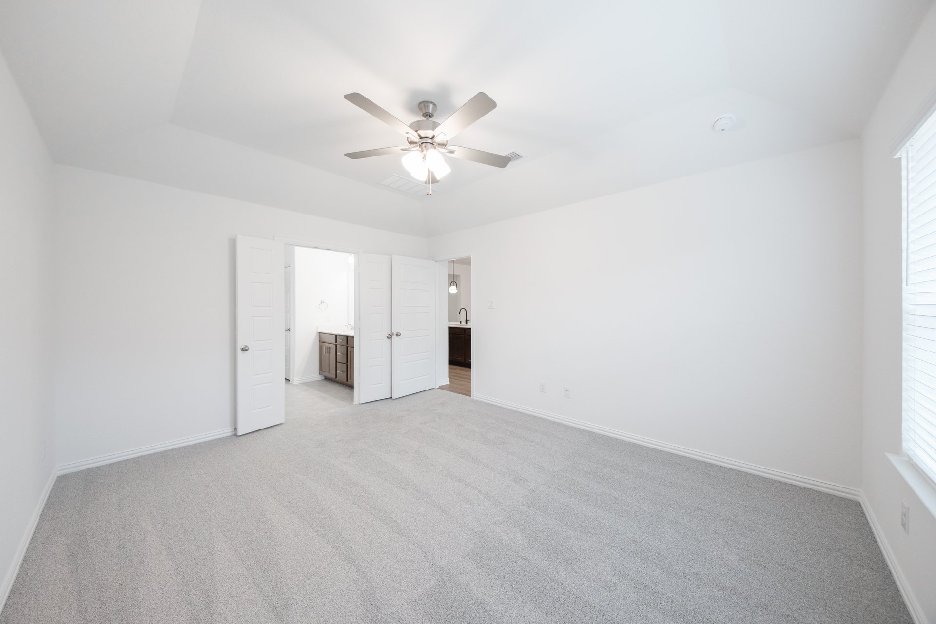 primary bedroom with carpet and ceiling fan