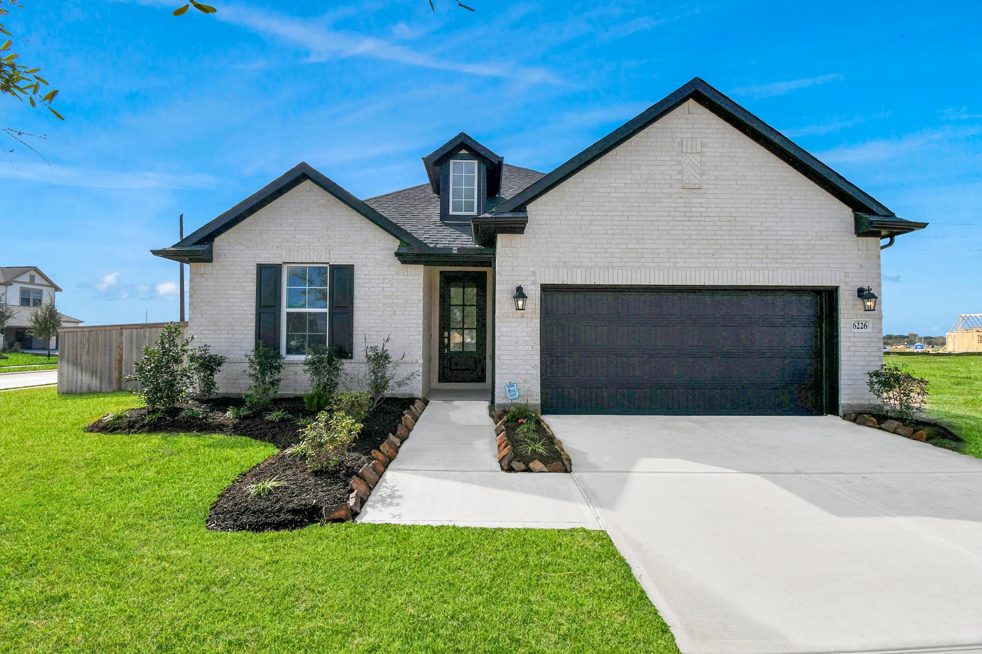 One-story home with brick and a black garage.