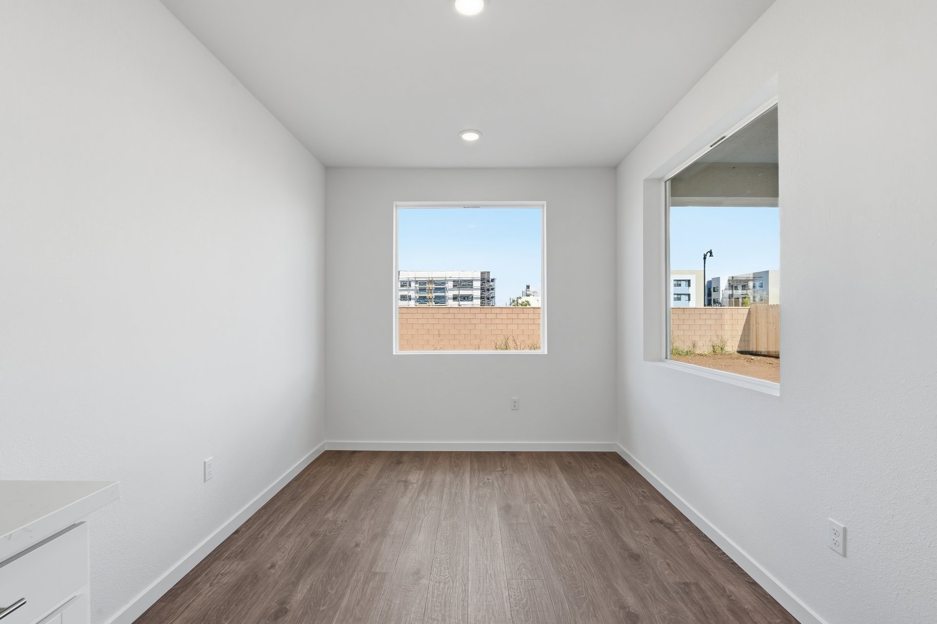 dining room with wood floors, white walls, and two windows