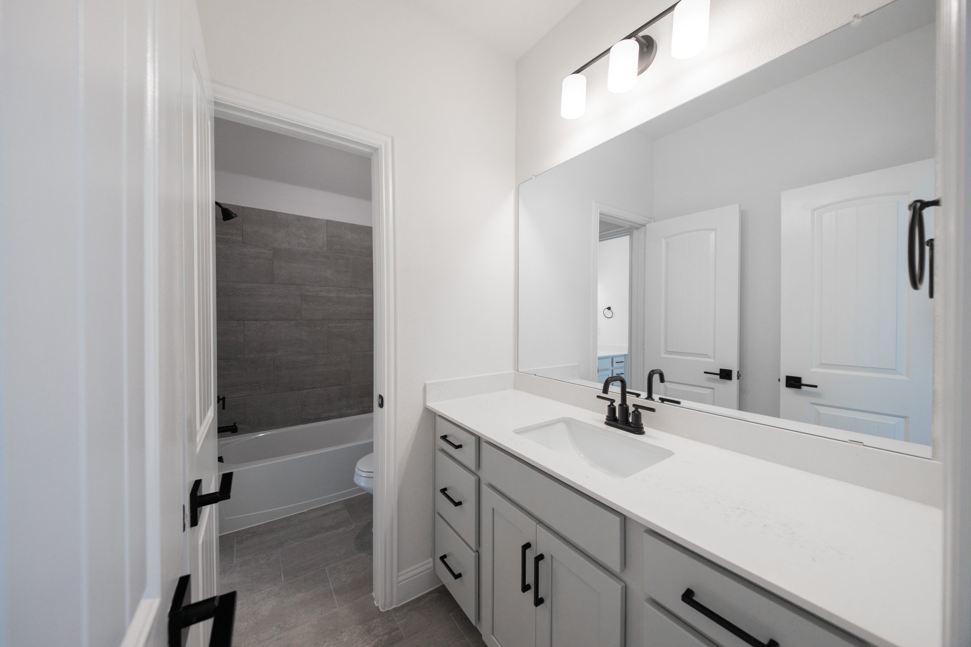 bathroom with white countertops and tile flooring