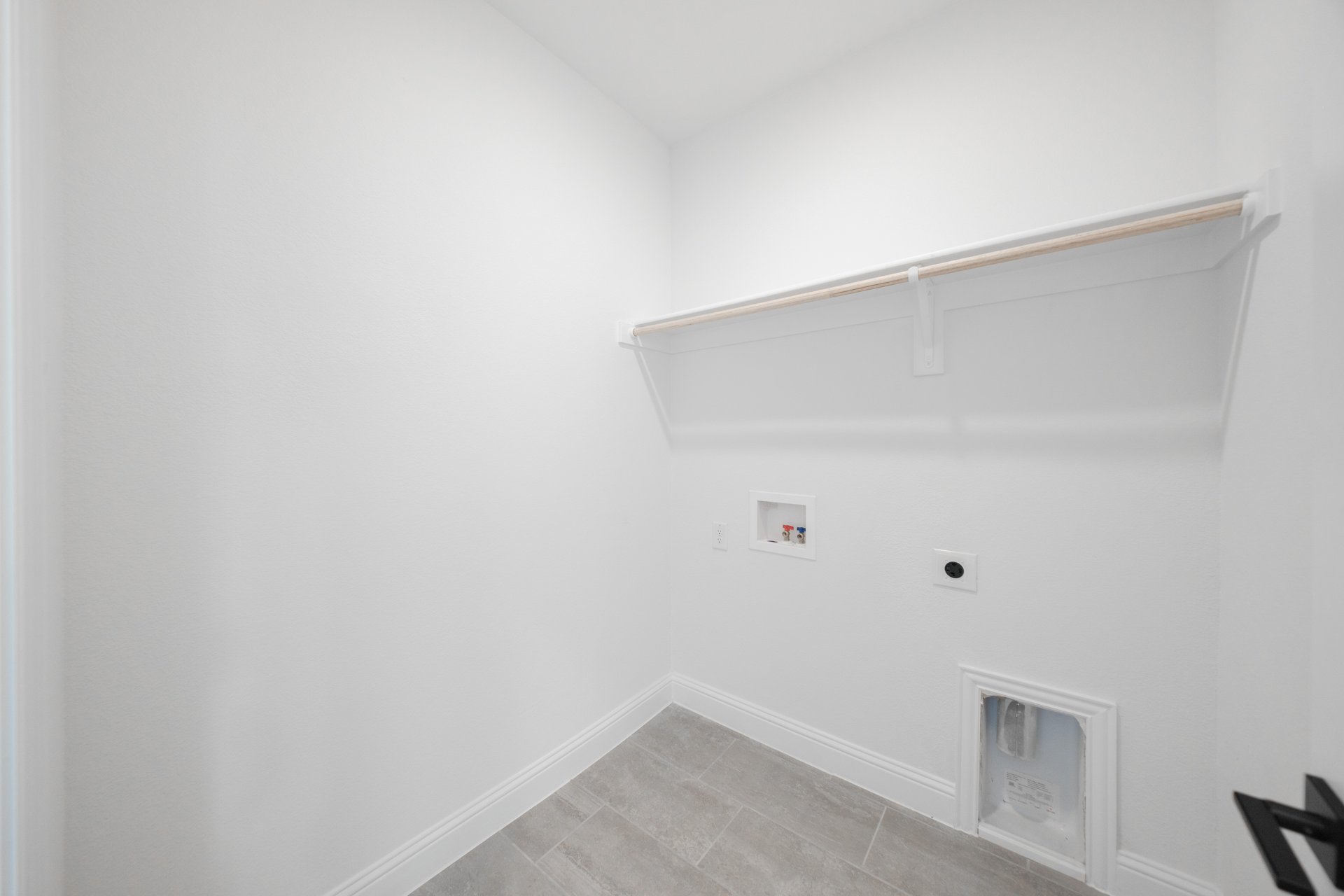 laundry room with tile flooring and shelf 