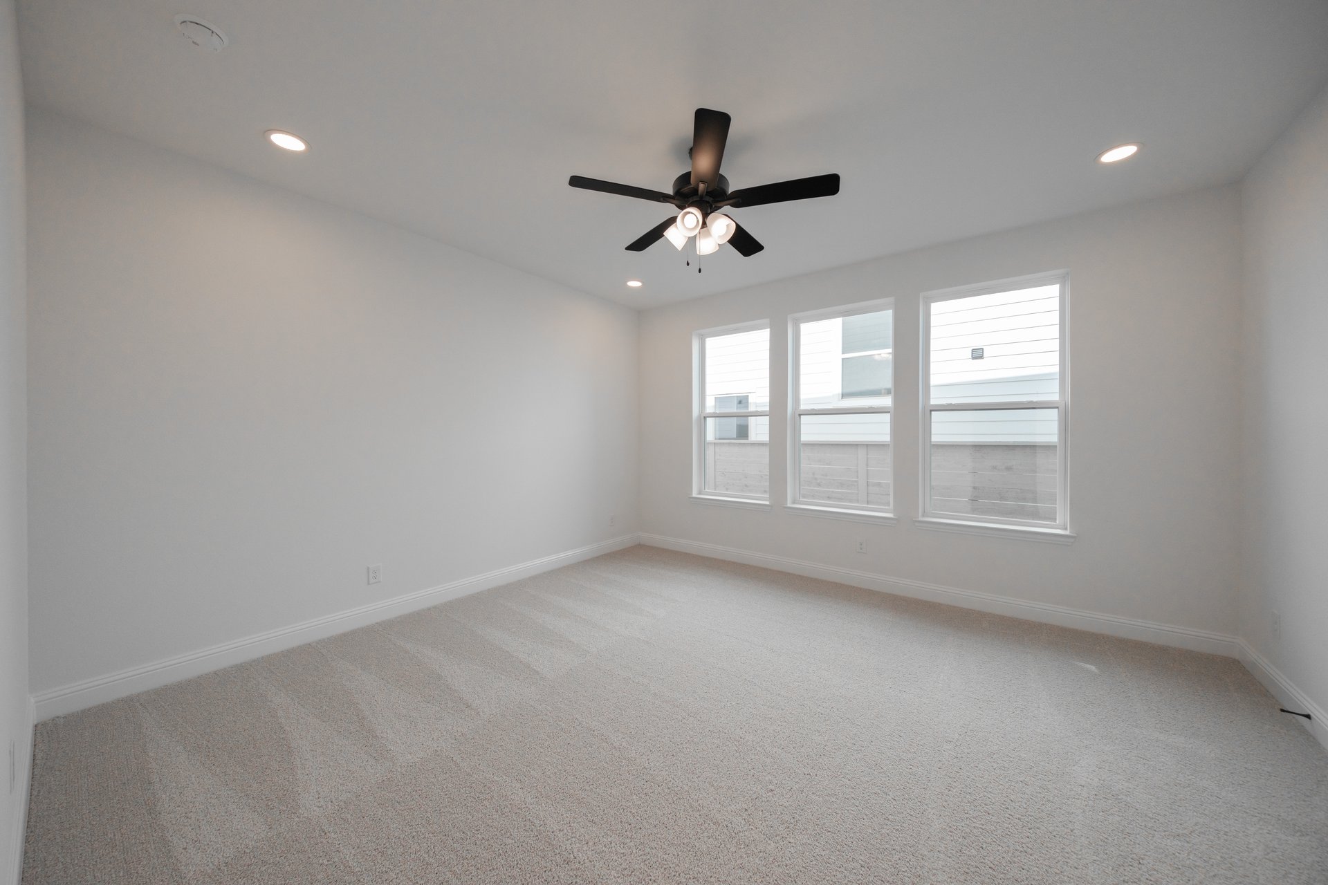 bedroom with large windows and ceiling fan 