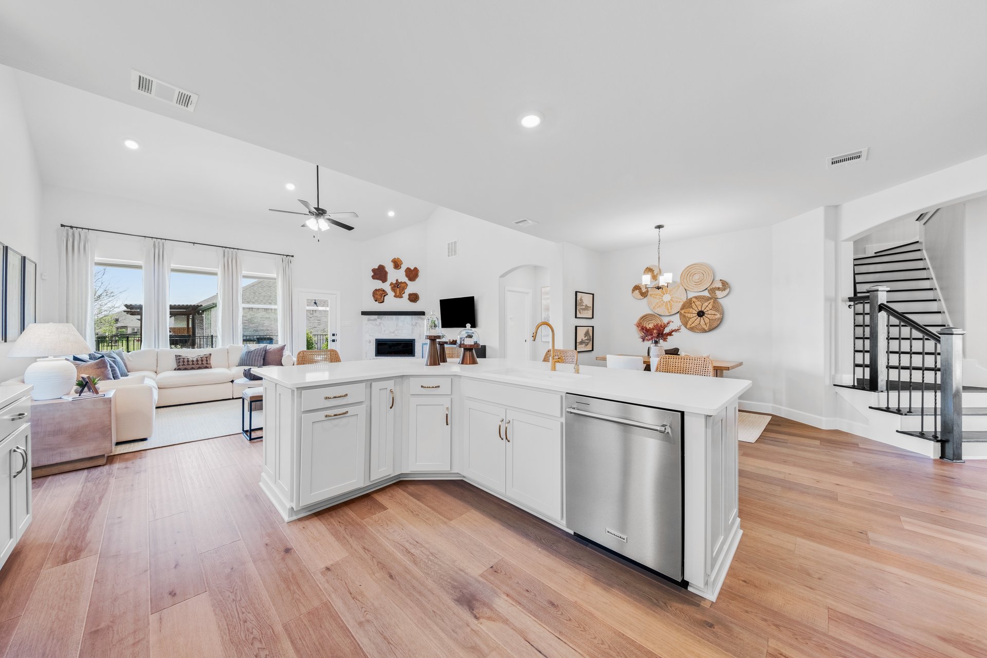 open kitchen with wood floors and white cabinets