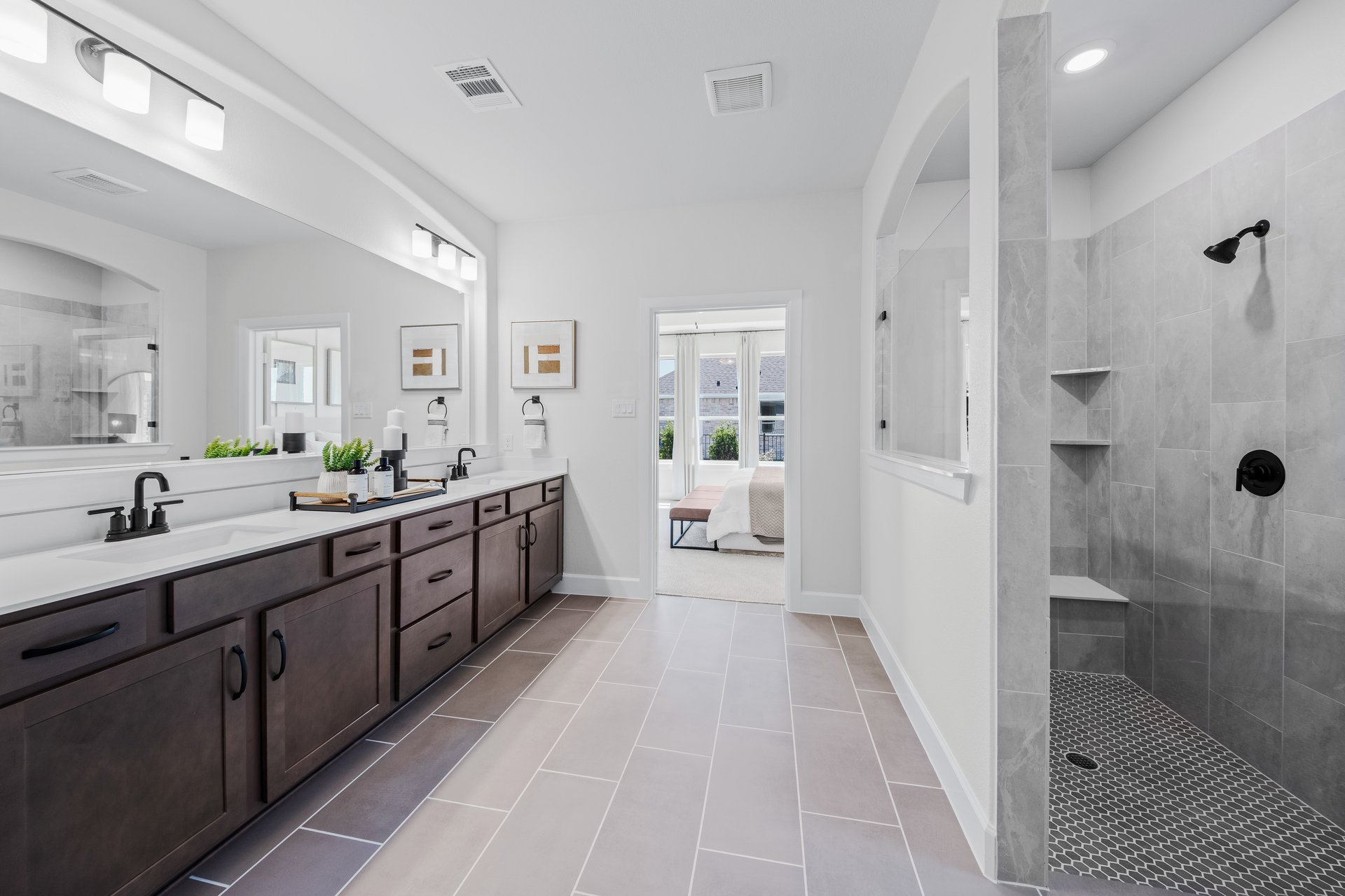 primary bathroom with walk-in shower and tile floors