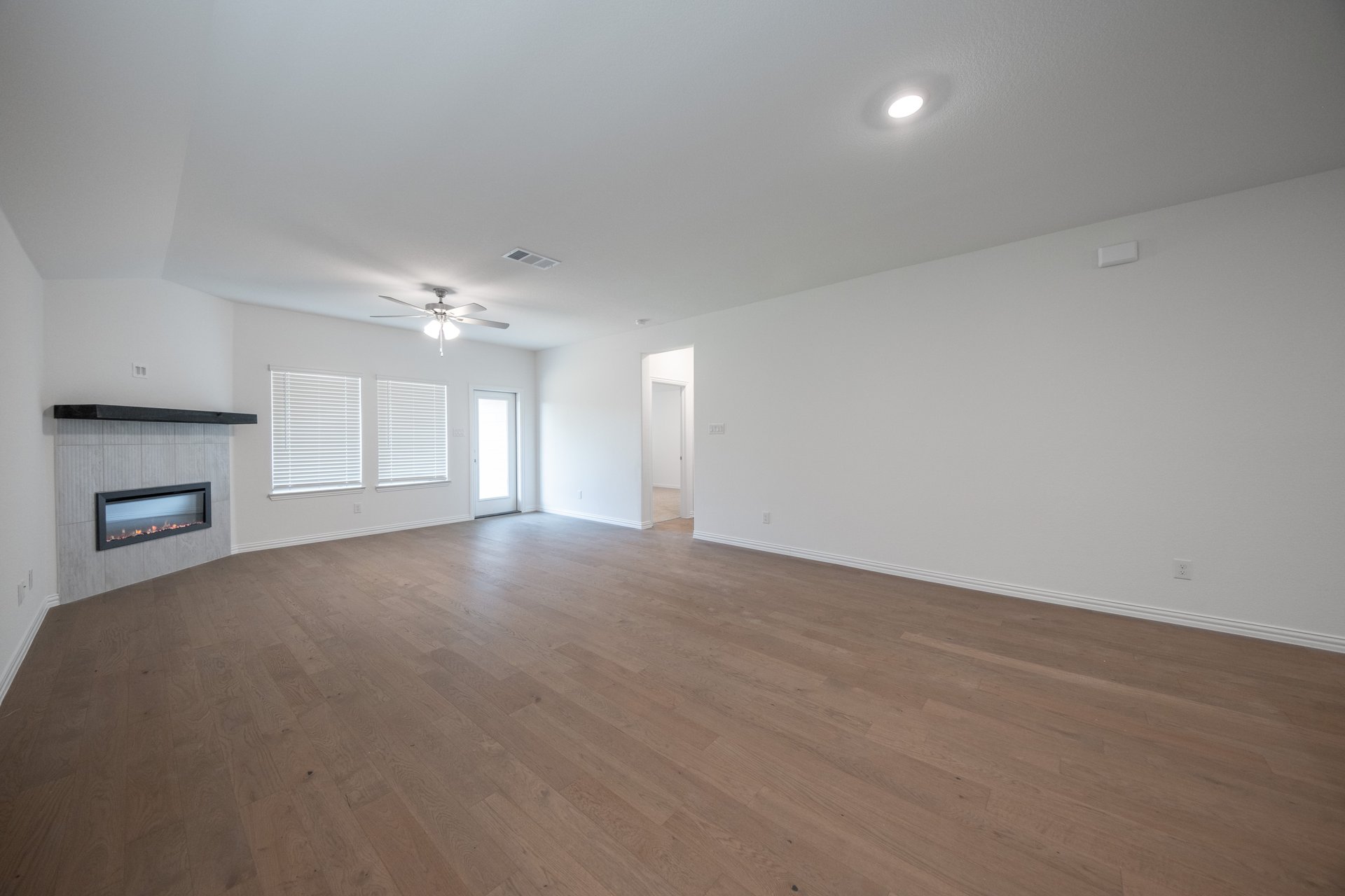 open great room with wood floors and fireplace