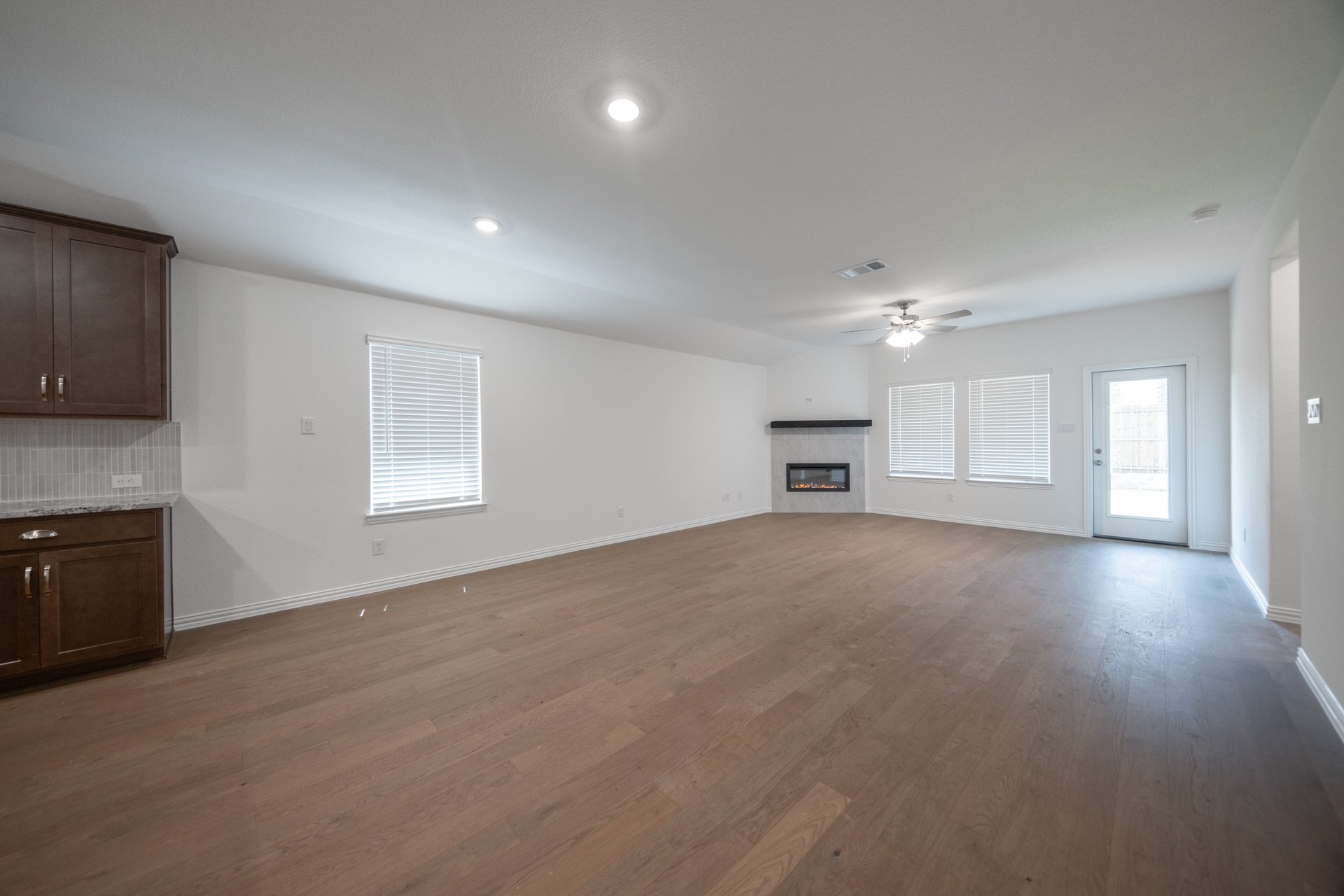 open great room with wood floors and fireplace