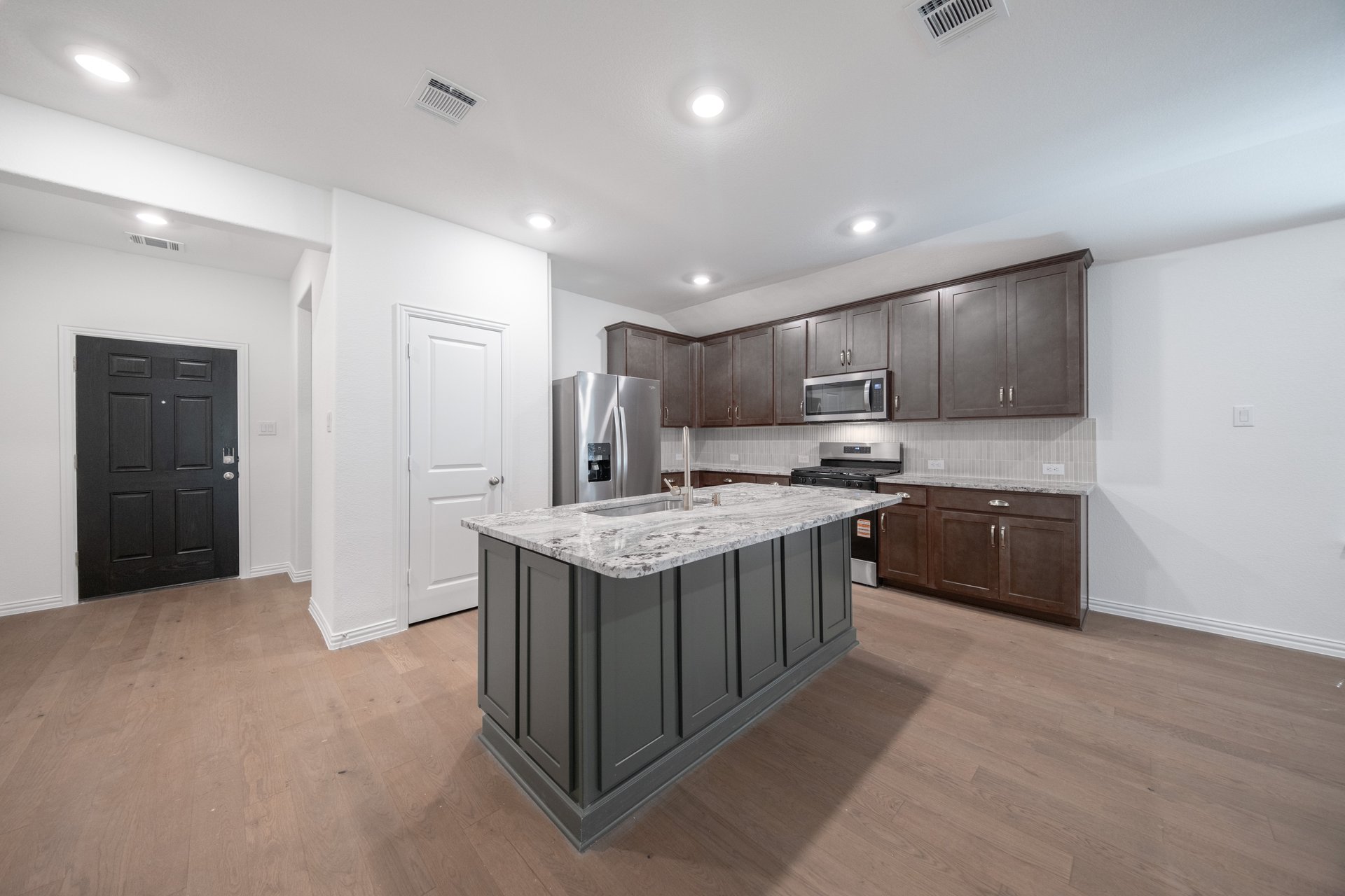open kitchen with wood floors and island