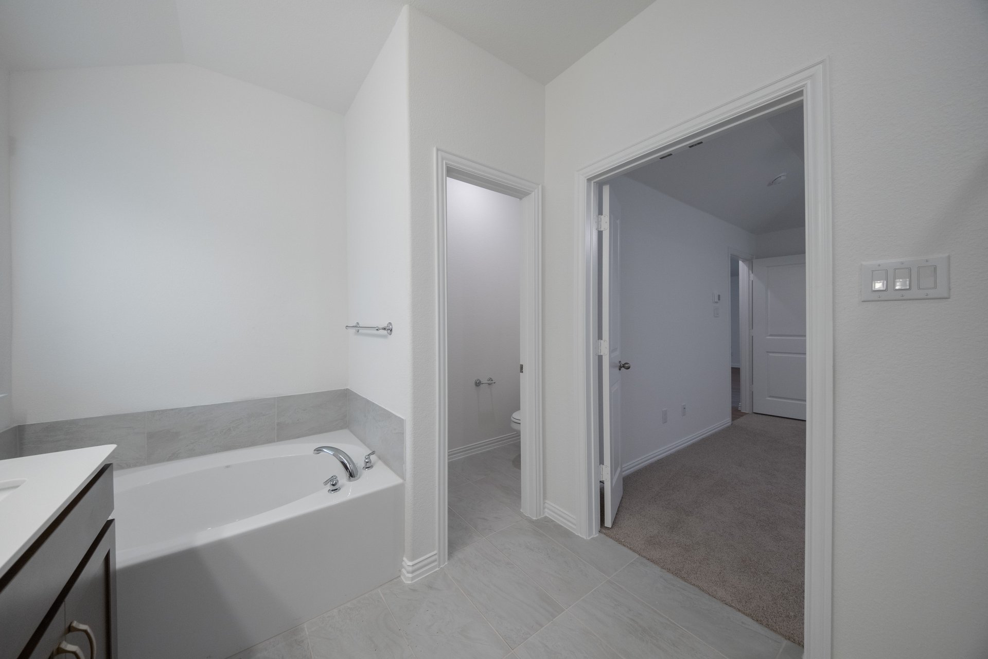 primary bathroom with soaking tub and tile floors
