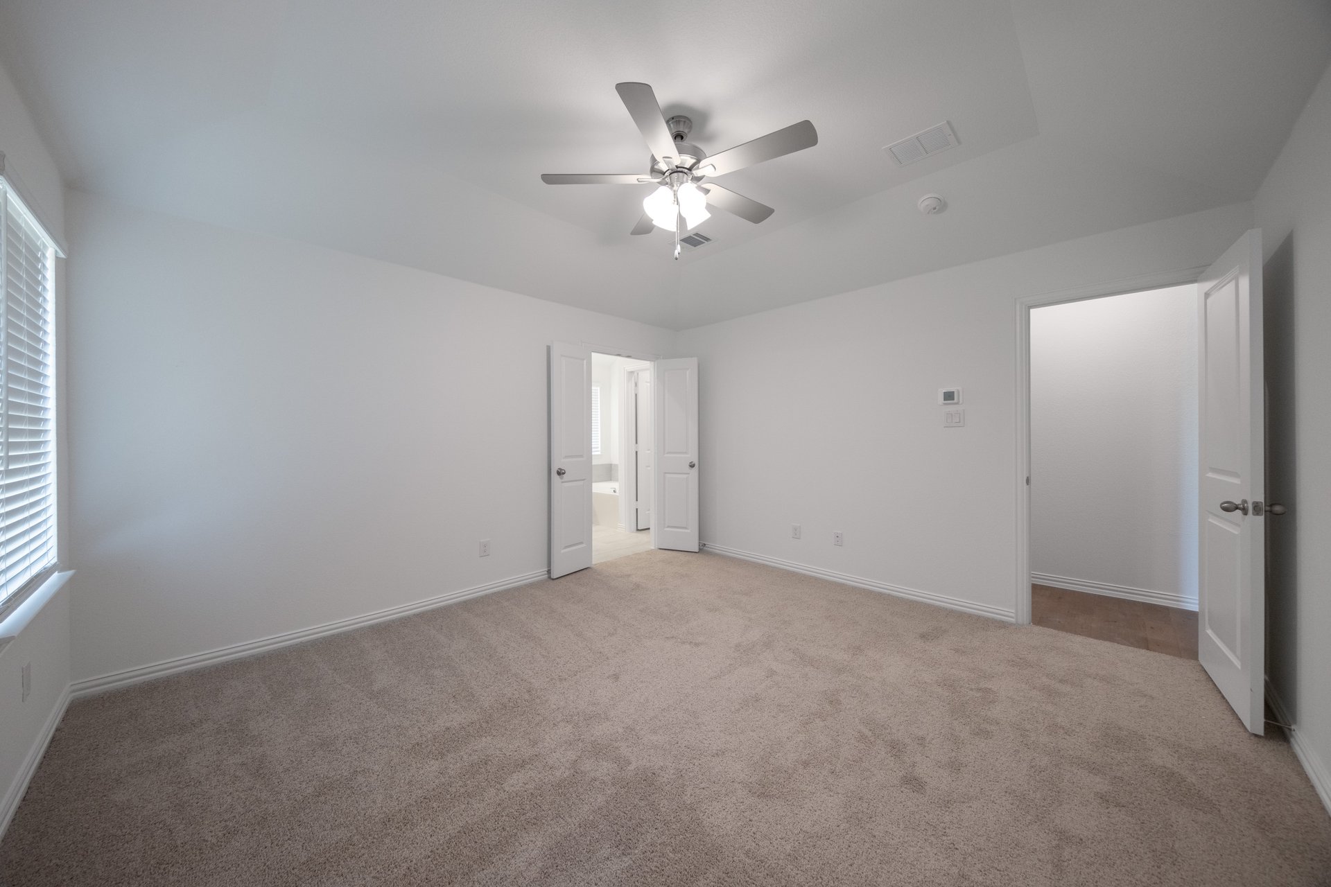 primary bedroom with carpet and ceiling fan