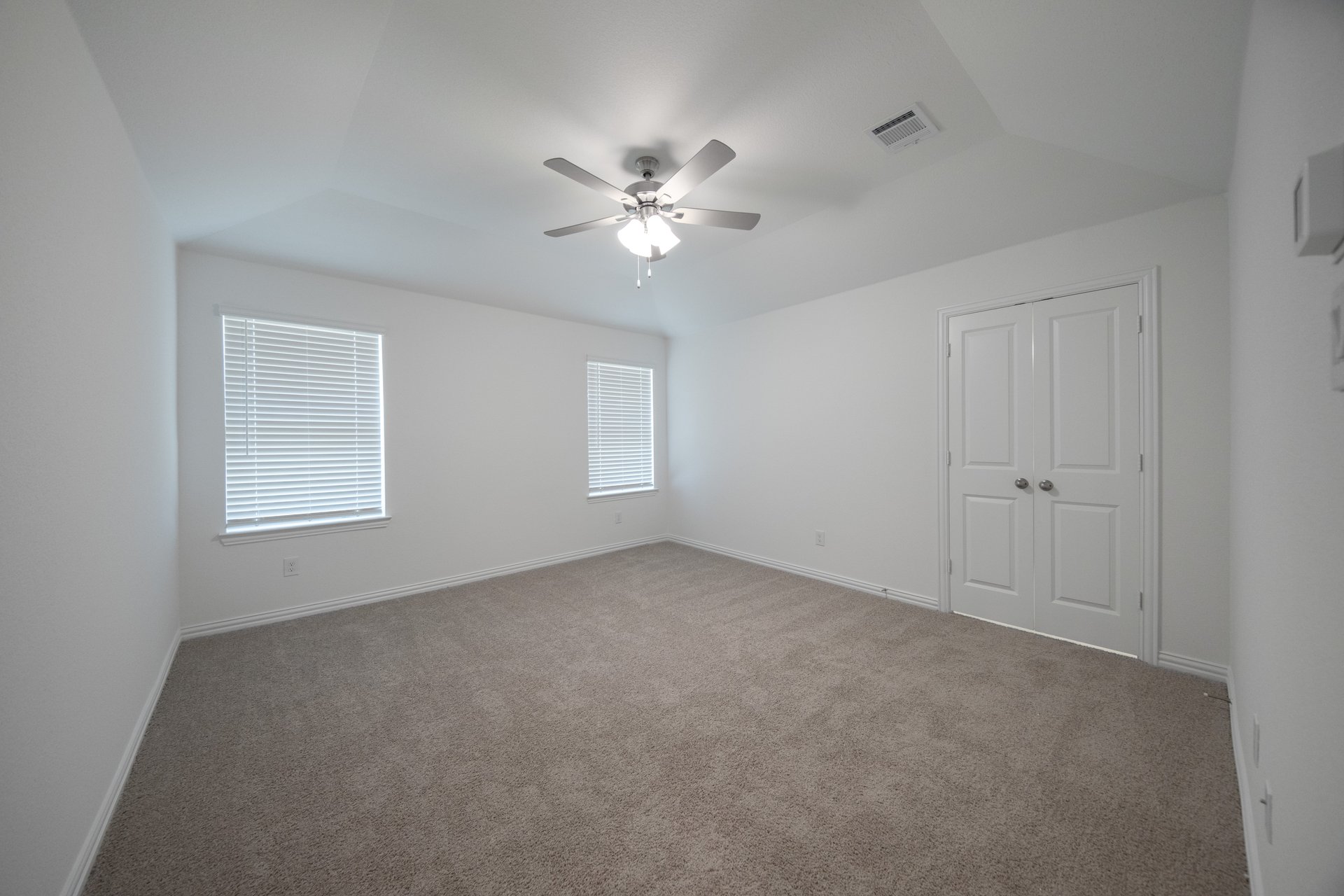 primary bedroom with carpet and windows