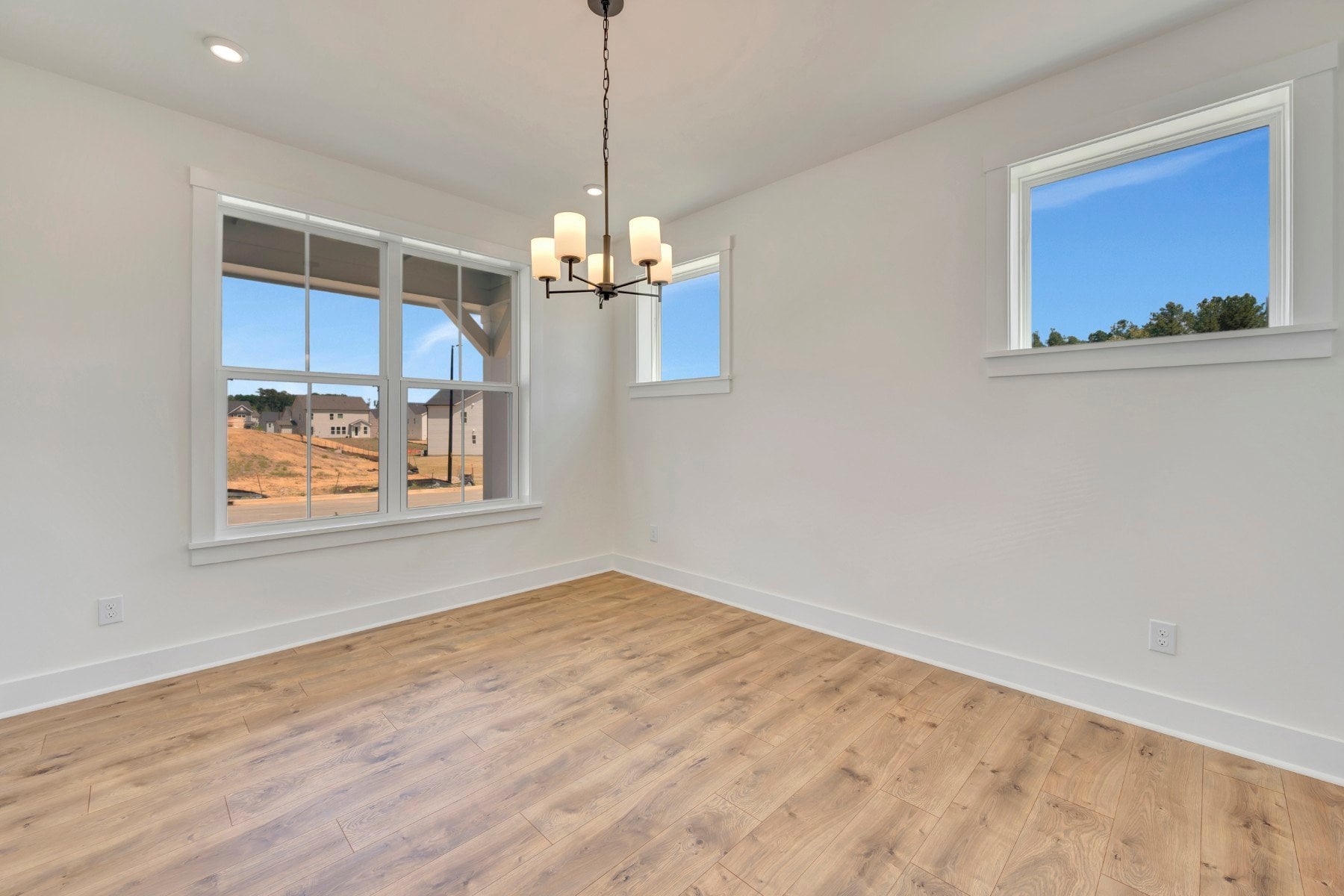 dining room with four windows and a chandalier