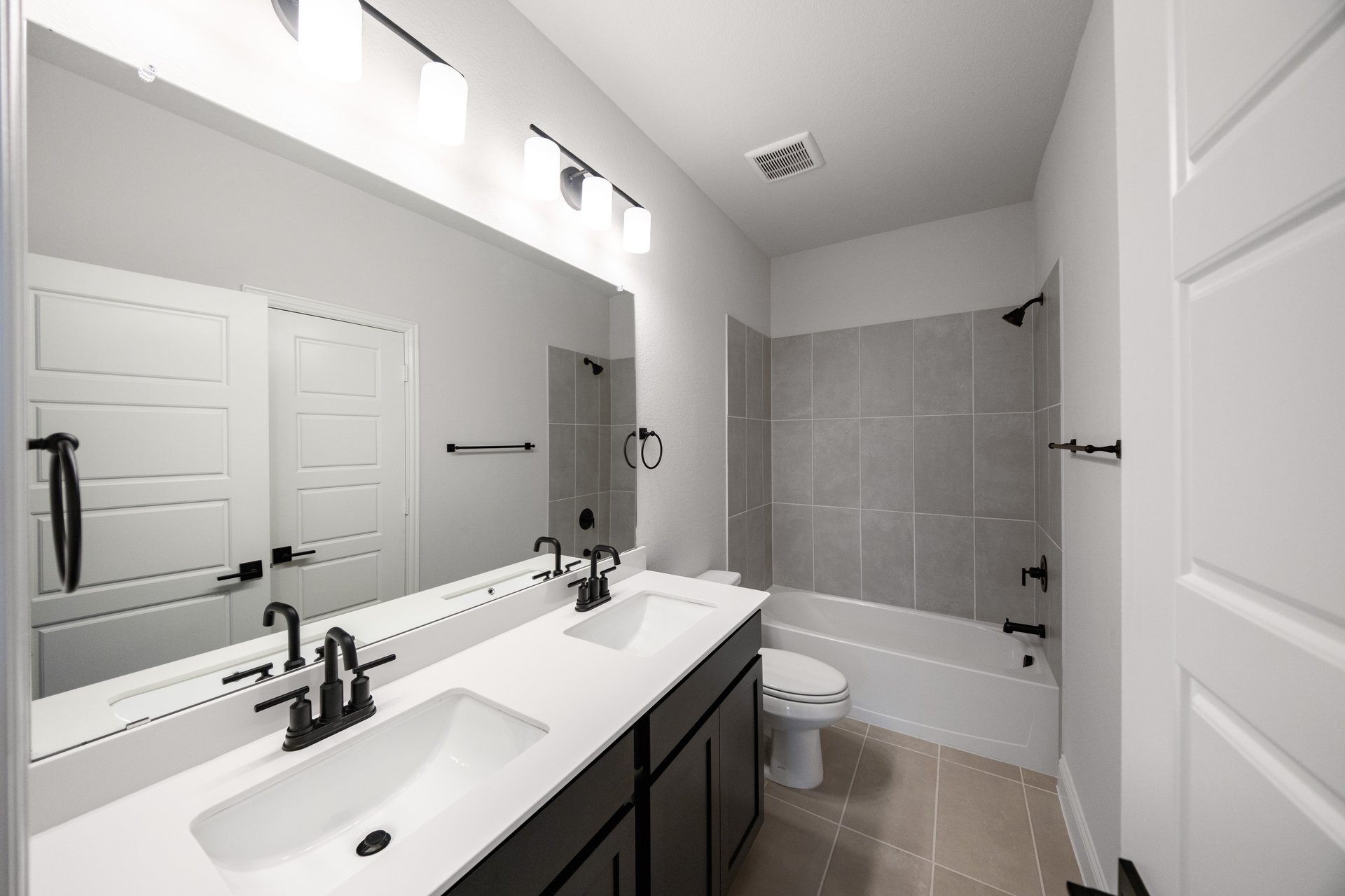 bathroom with two sinks and black cabinets 