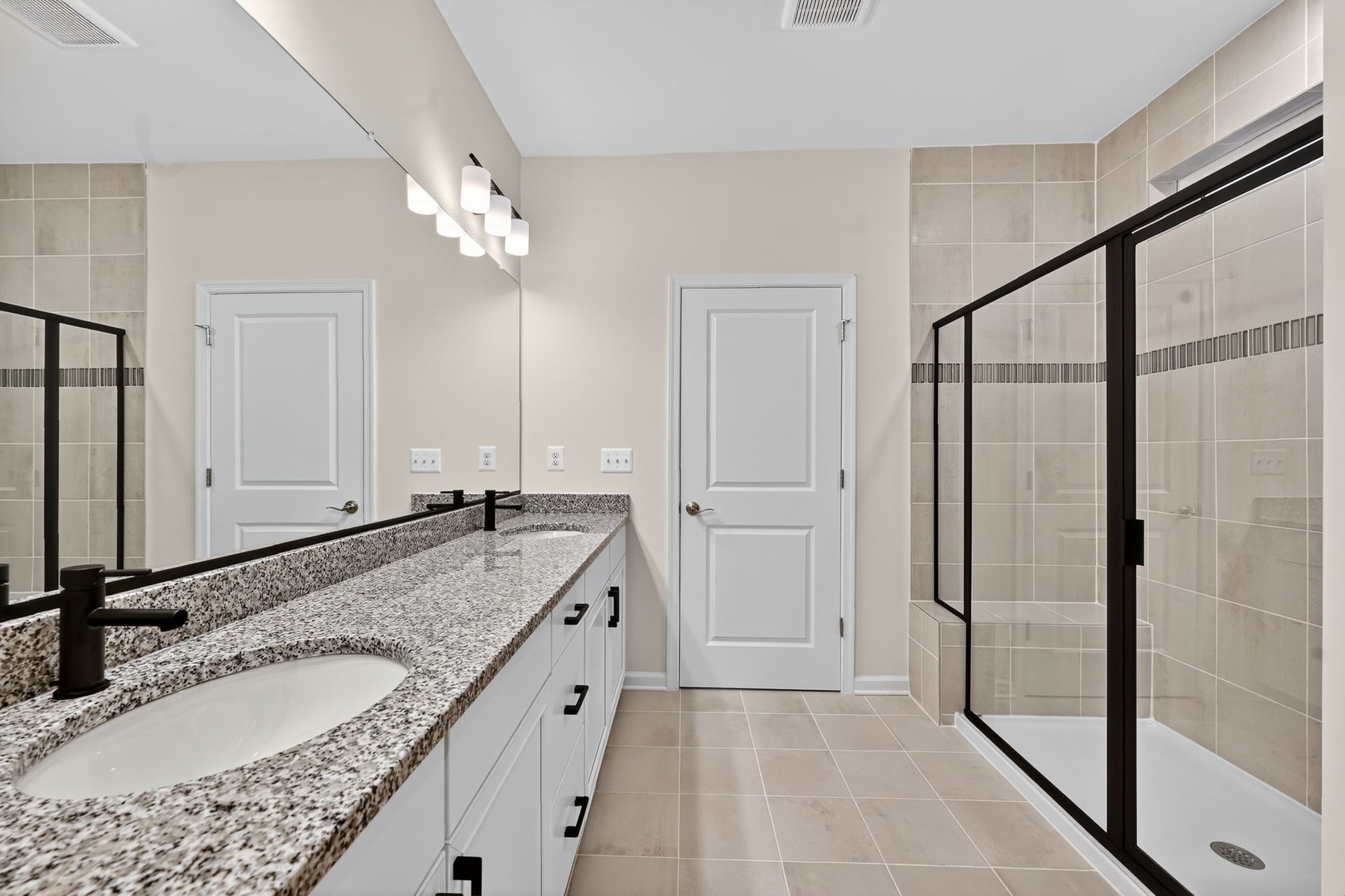 primary bedroom with tray ceiling and door to bathroom and closet