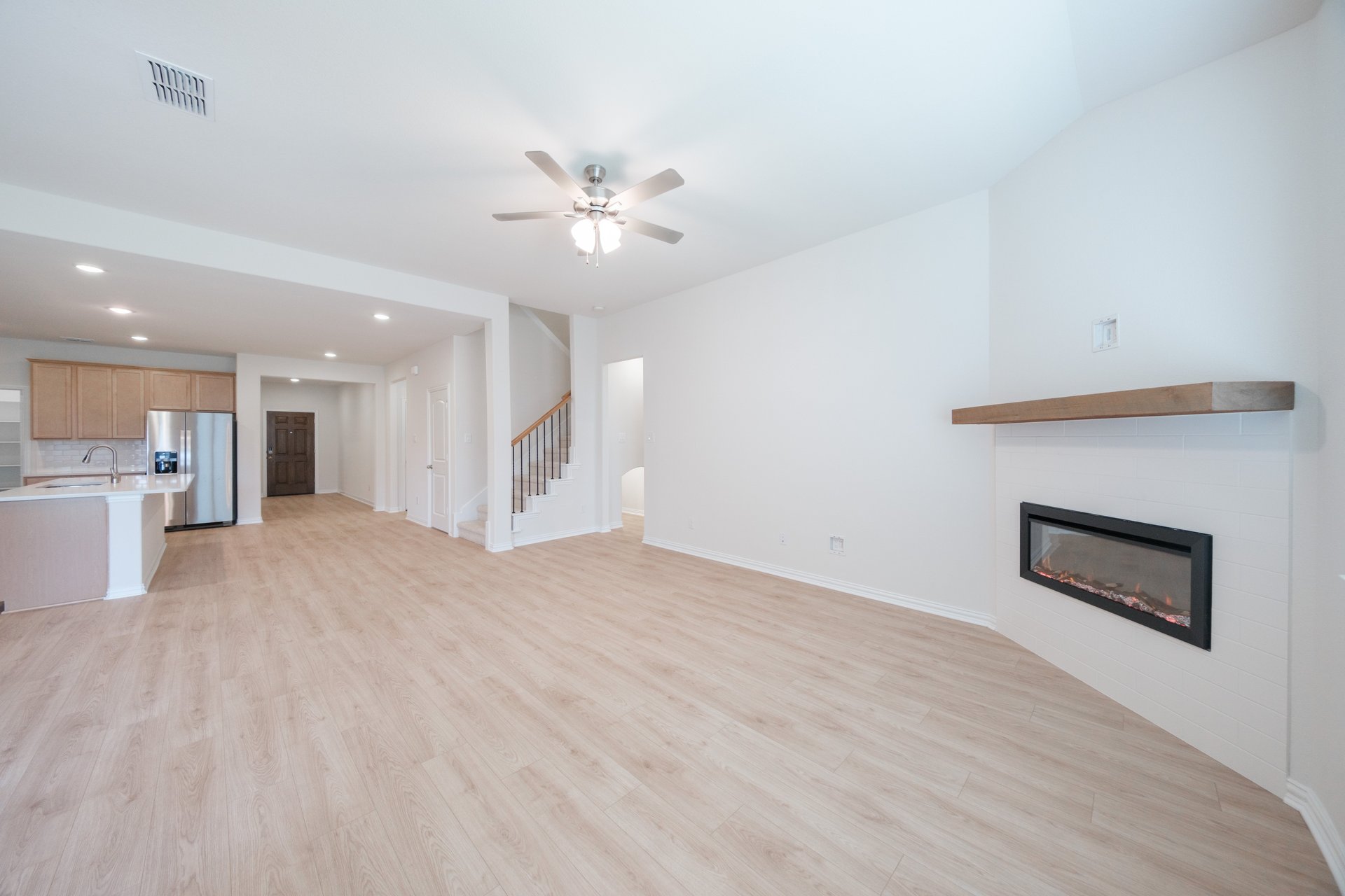 open great room with wood floors and fireplace